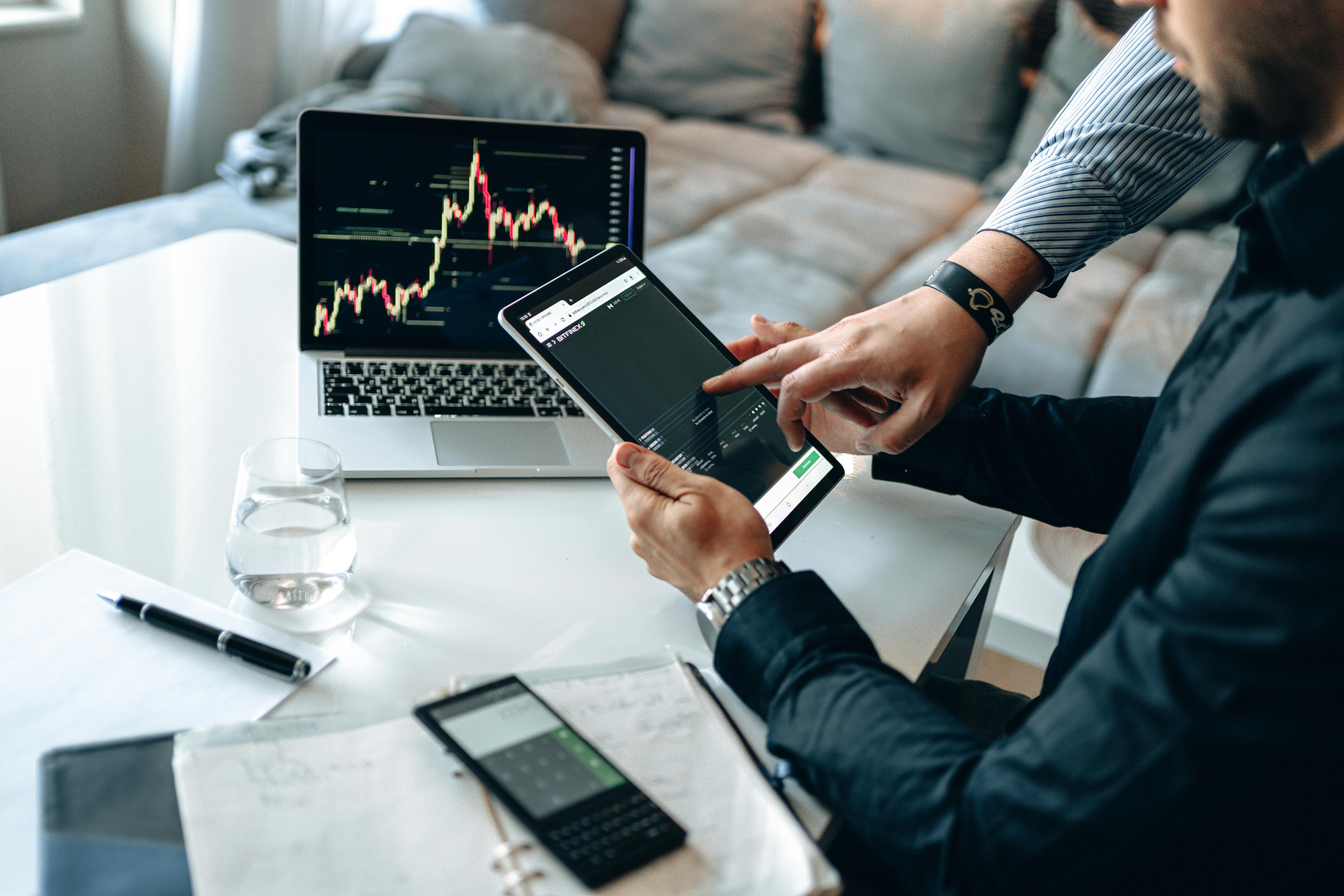 Man checking data on a tablet and a laptop | Source: Pexels