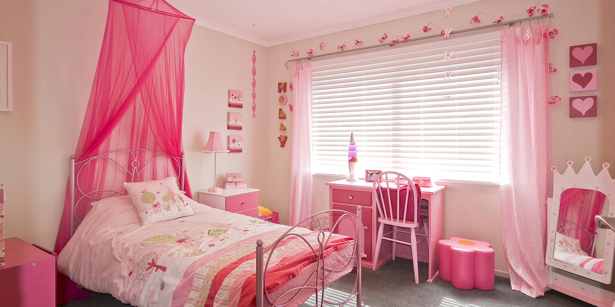 Bright pink-themed girl's bedroom with whimsical decor and cozy charm | Source: Shutterstock