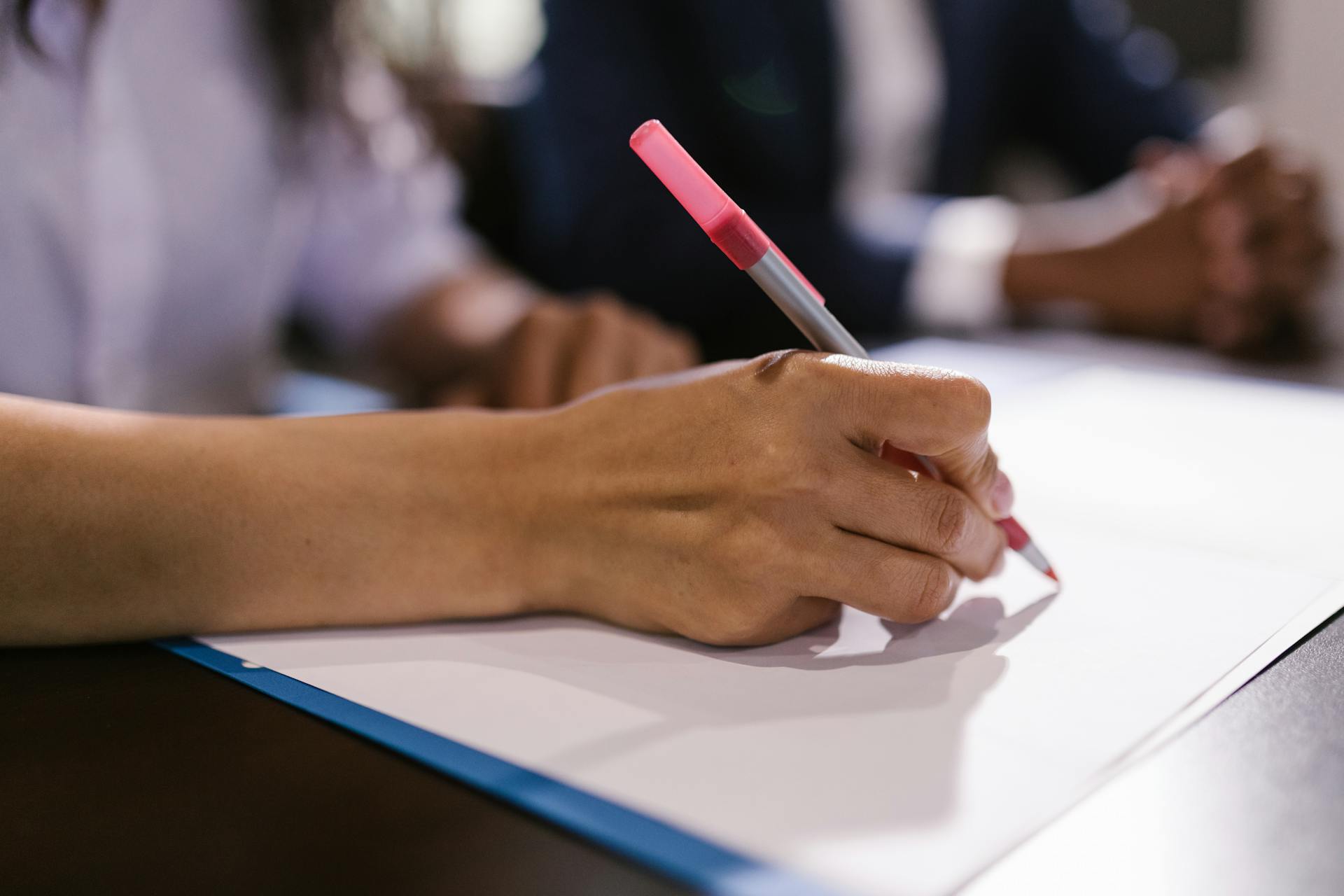 A person writing on a paper | Source: Pexels