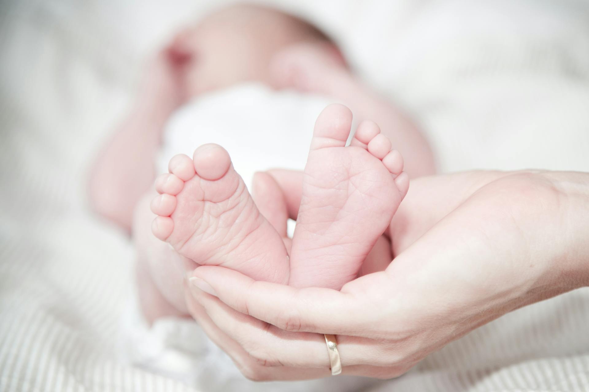 A person holding a baby's feet | Source: Pexels