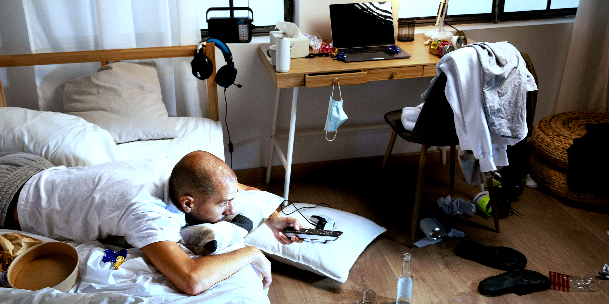 A man lying on a bed in a dirty room | Source: Freepik.com