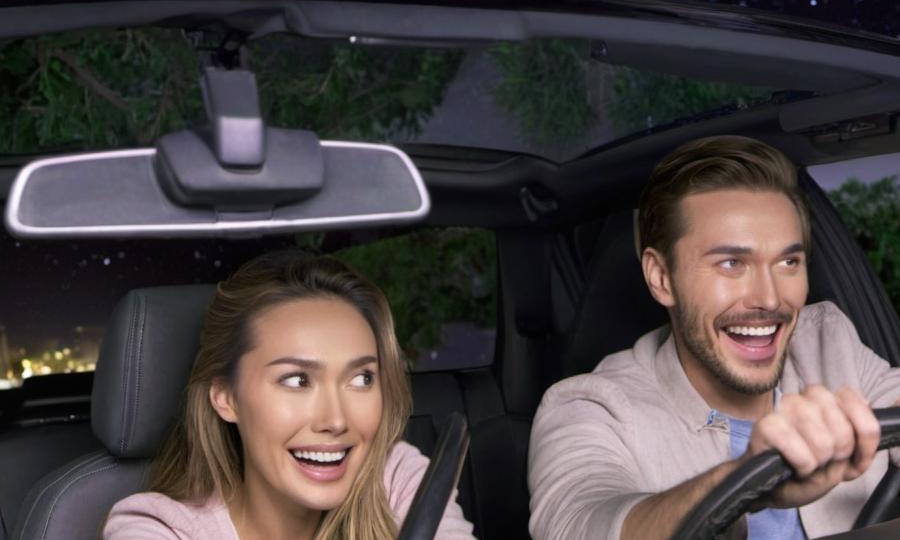 A happy-looking man and woman driving in a car | Source: no source