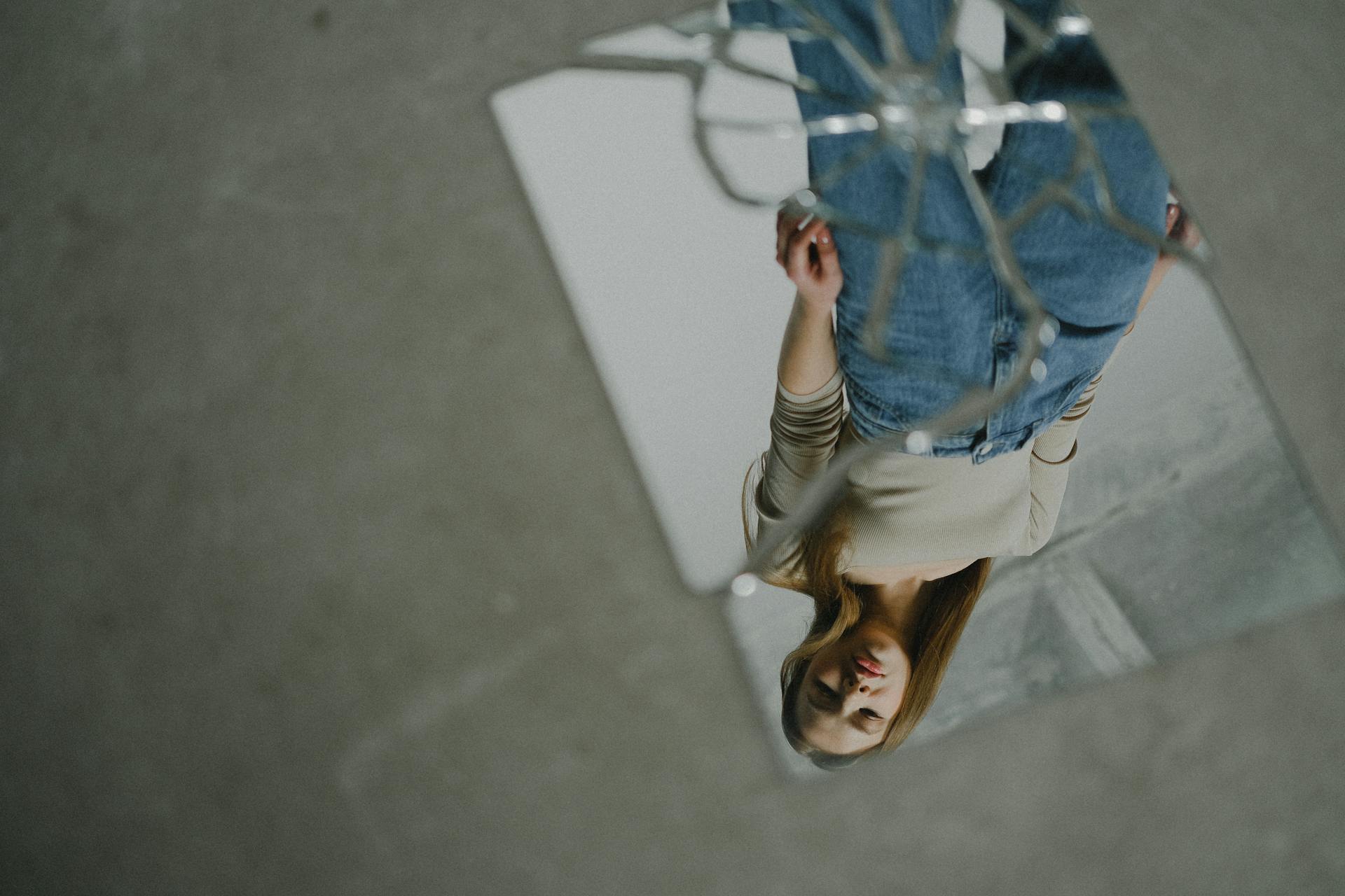 A woman's reflection in a broken mirror | Source: Pexels