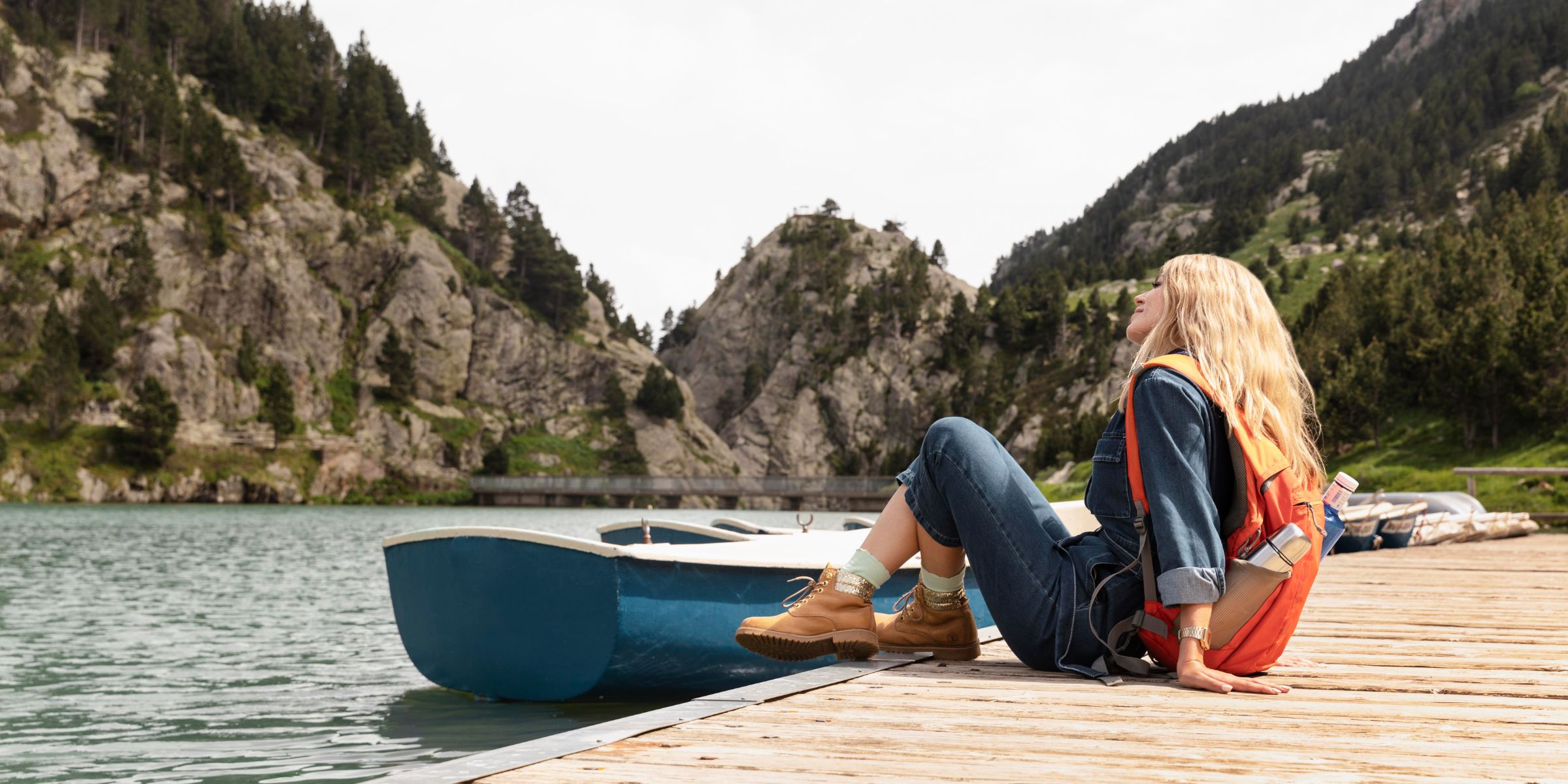 A young woman sitting on a dock | Source: No source
