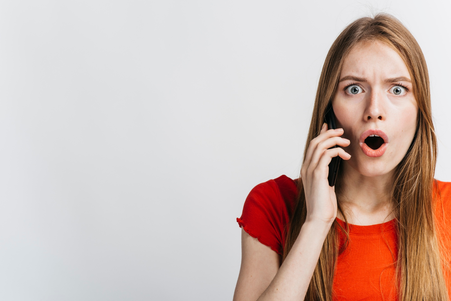 A shocked woman talking on the phone | Source: Freepik