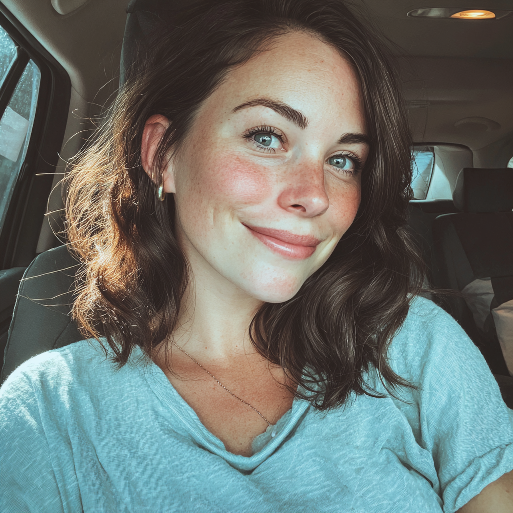 A smiling woman sitting in a car | Source: No source