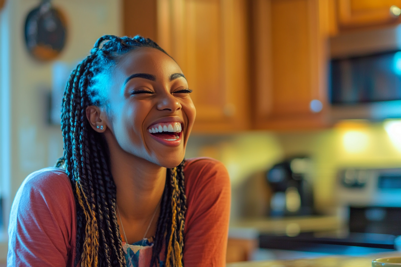 A woman laughing in a kitchen | Source: No source