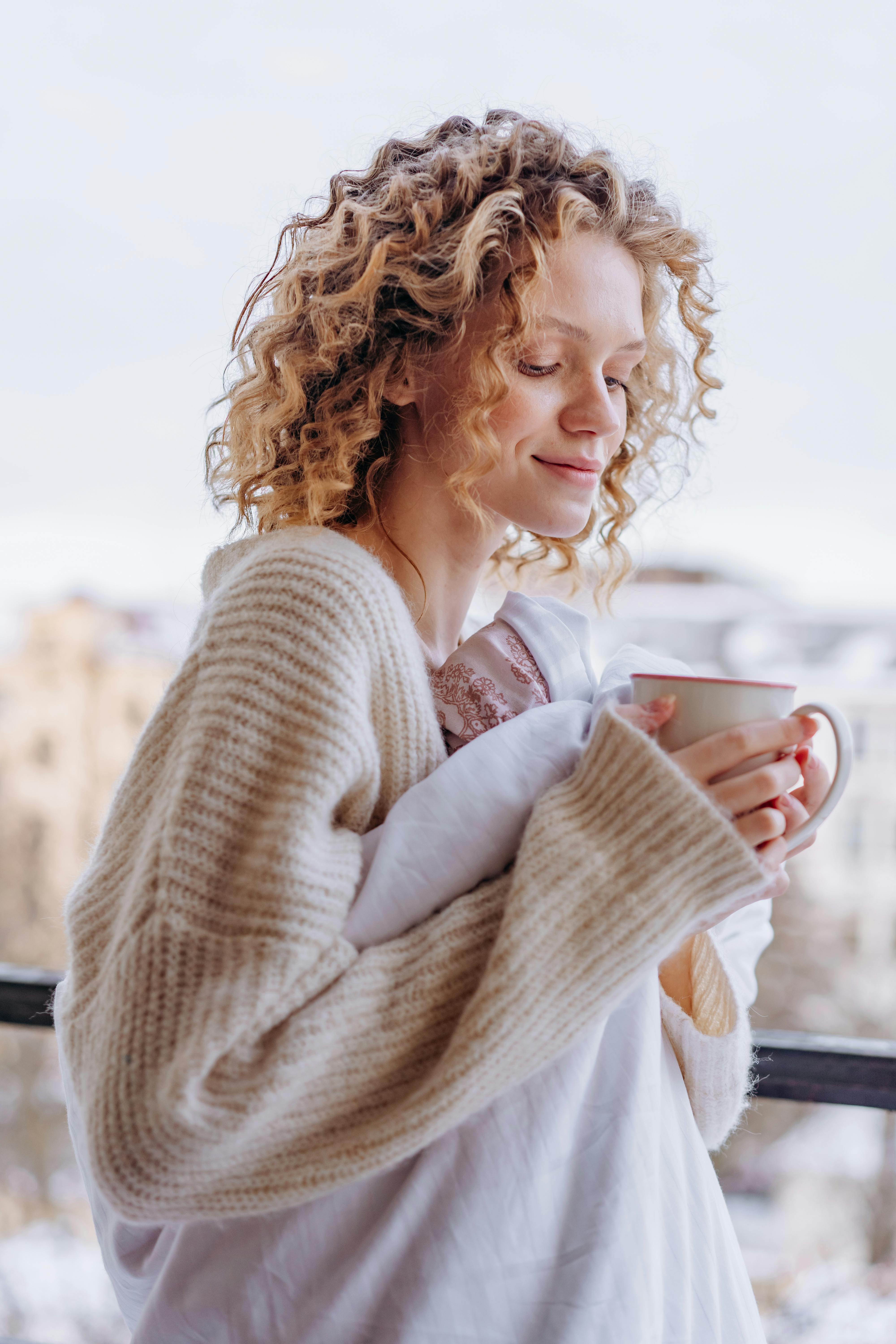 Contented woman holding a ceramic mug | Source: Pexels
