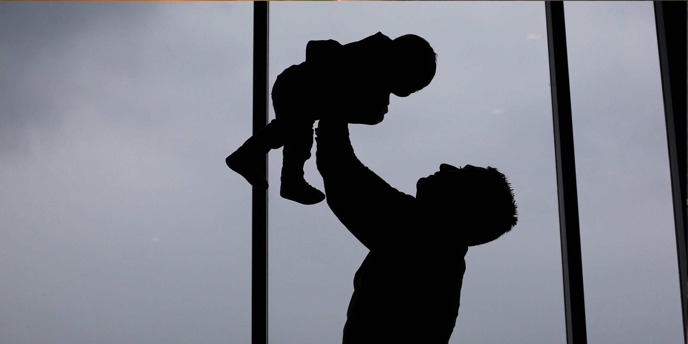 Silhouette of a father and baby at home on a cloudy day | Source: Shutterstock