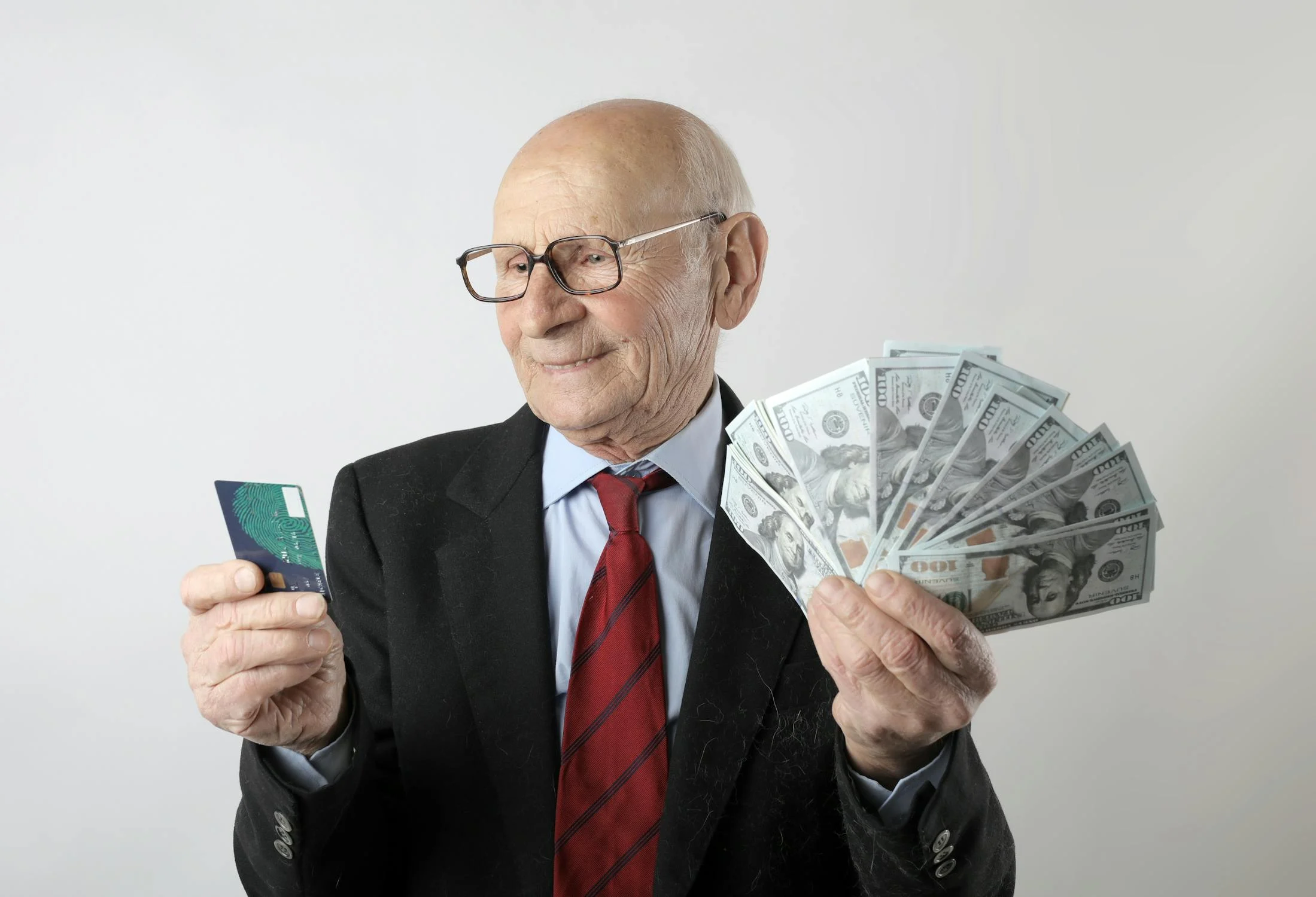 An elderly man holding money | Source: Pexels