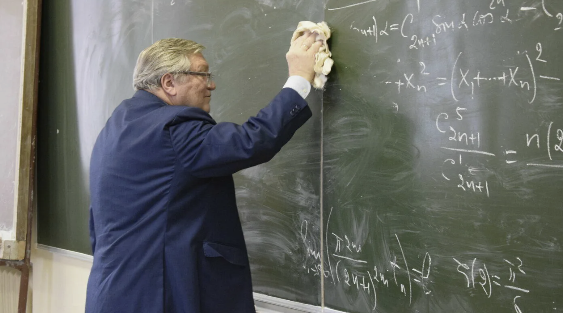 The old professor wipes the blackboard | Source: Shutterstock