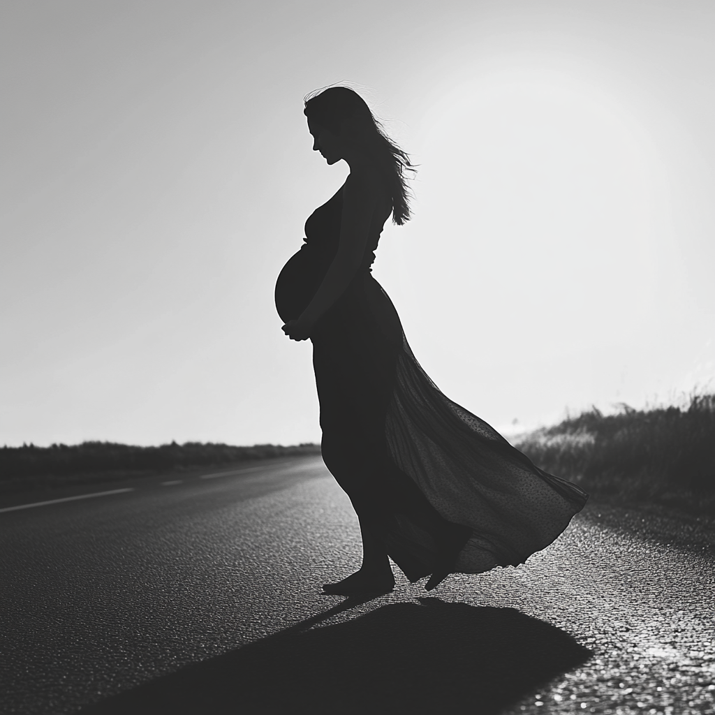 Grayscale shot of a pregnant woman on the road | Source: No source