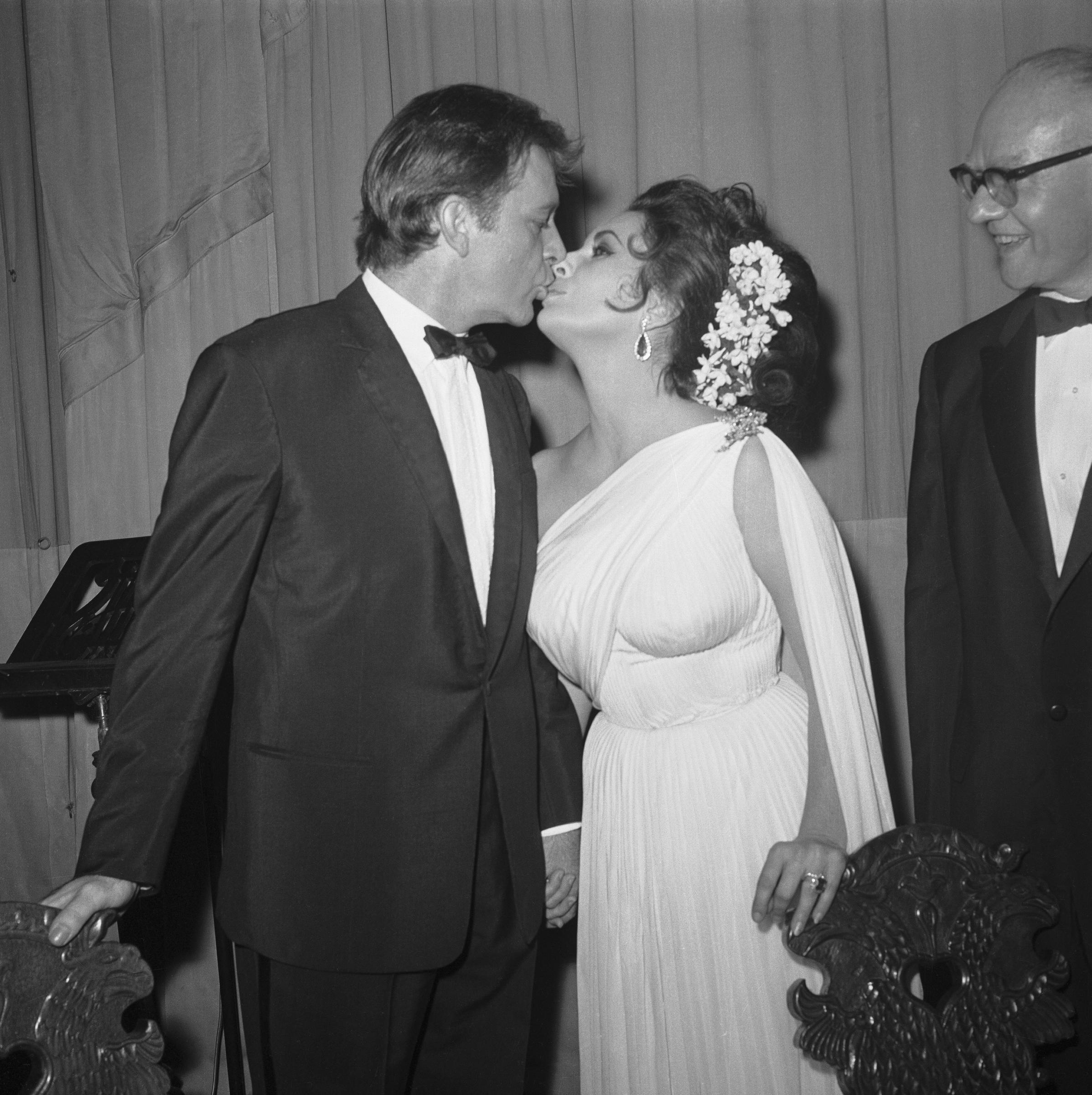 Richard Burton kisses Elizabeth Taylor at the Lunt-Fontanne Theatre in New York, circa 1964 | Source: Getty Images