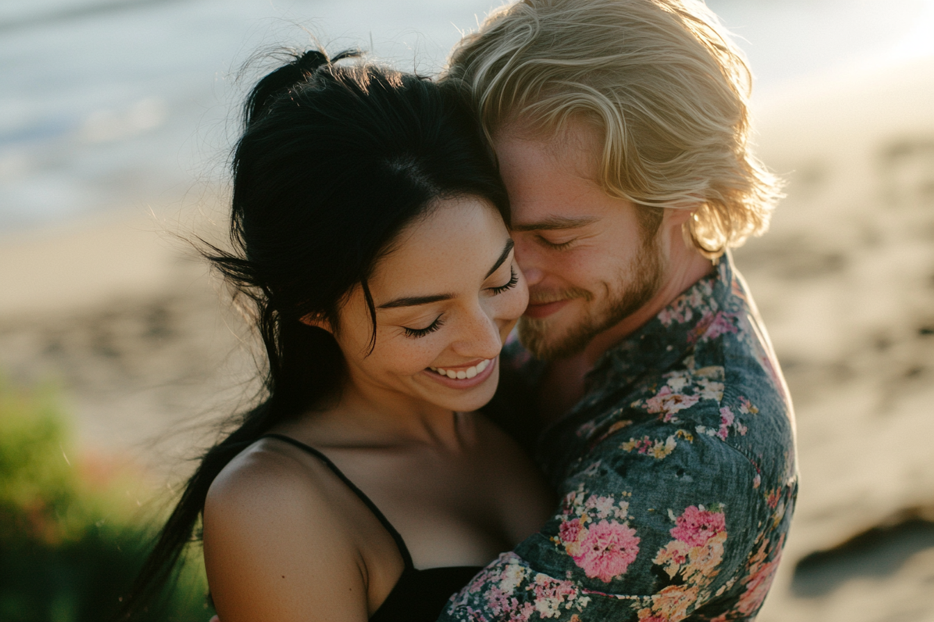 A black-haired woman and a blonde man in their 30s cuddle close on the beach | Source: No source