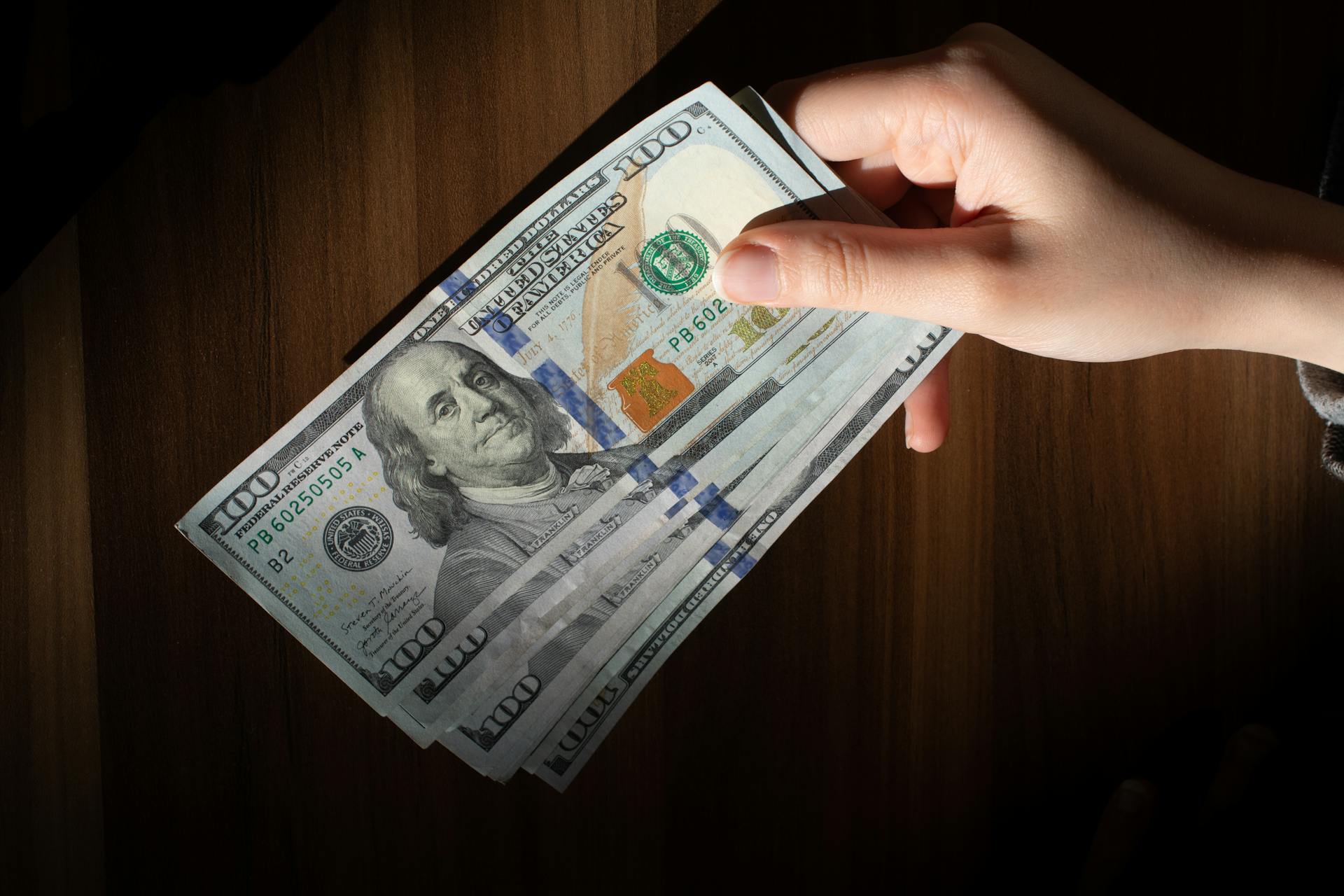 A woman placing money on a table | Source: Pexels