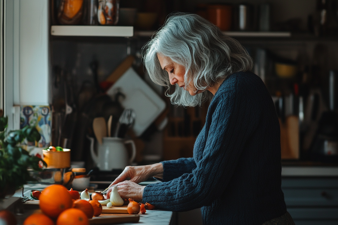 Woman in her 50s in the kitchen cutting ingredients with concentration | Source: No source