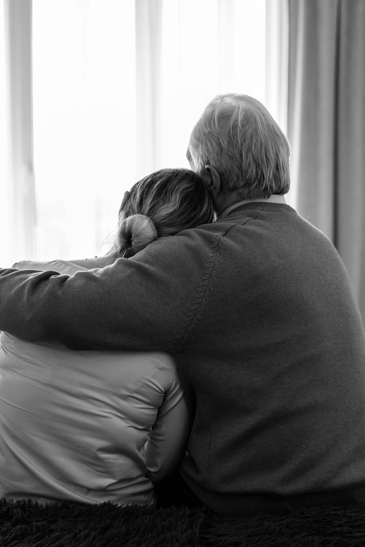 A woman leaning on her partner's shoulder as he embraces her | Source: Pexels