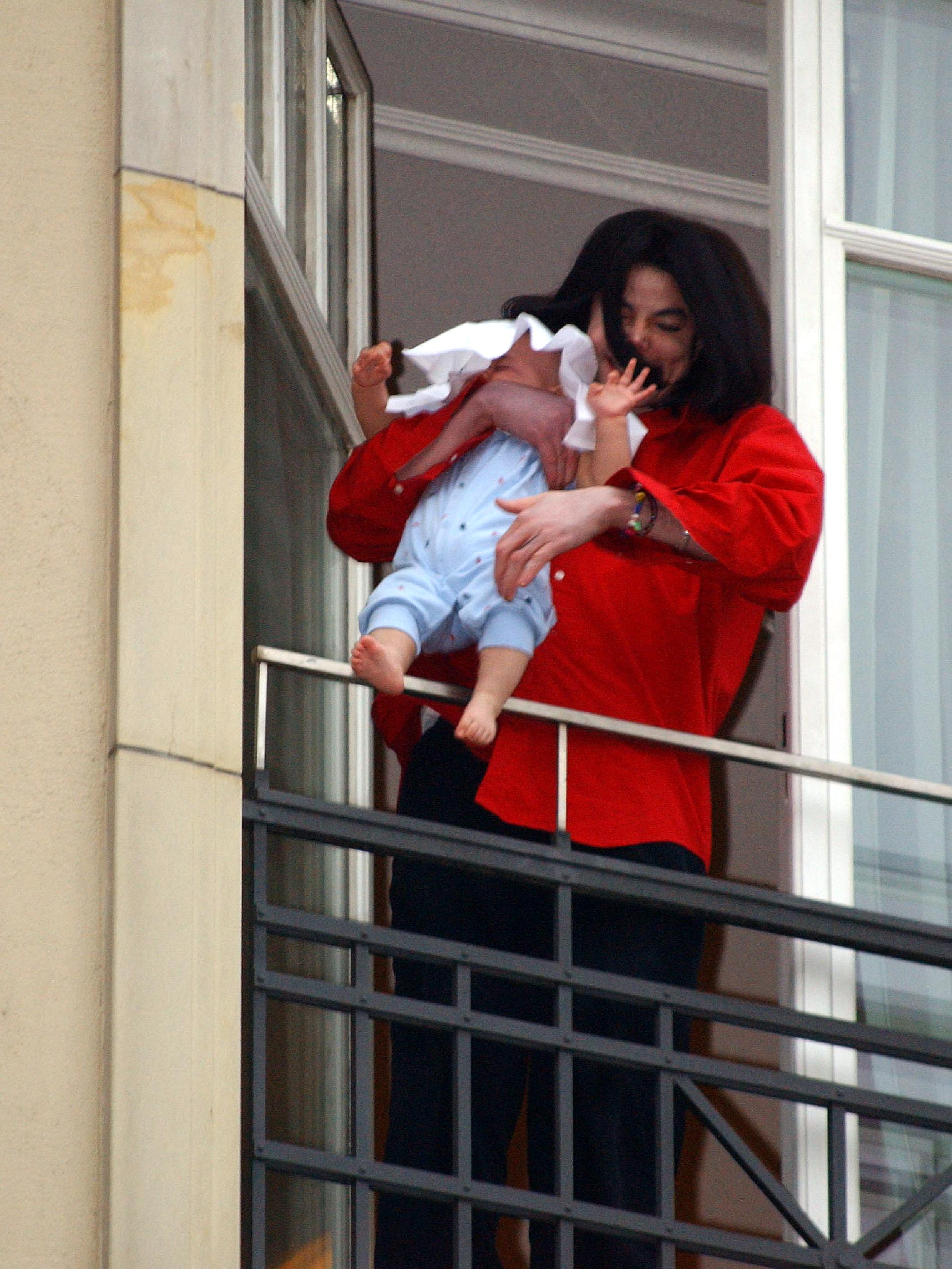 Michael Jackson holds his son Bigi Jackson over the balcony of the Adlon Hotel on November 19, 2002, in Berlin, Germany | Source: Getty Images