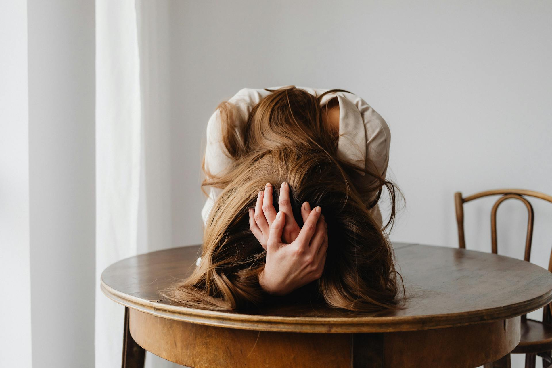 A depressed woman seated at a table | Source: Pexels