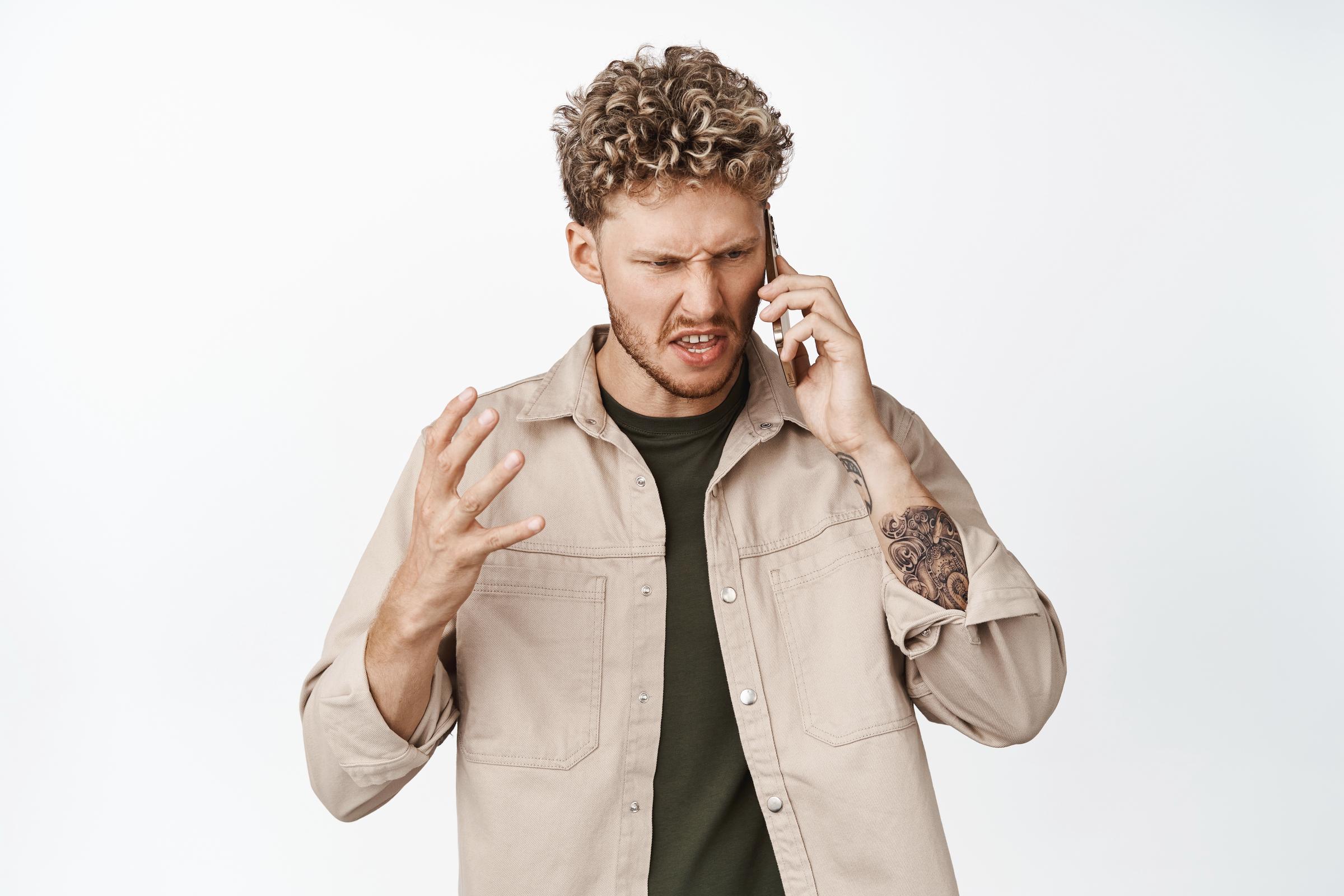 An upset man on a call | Source: Freepik