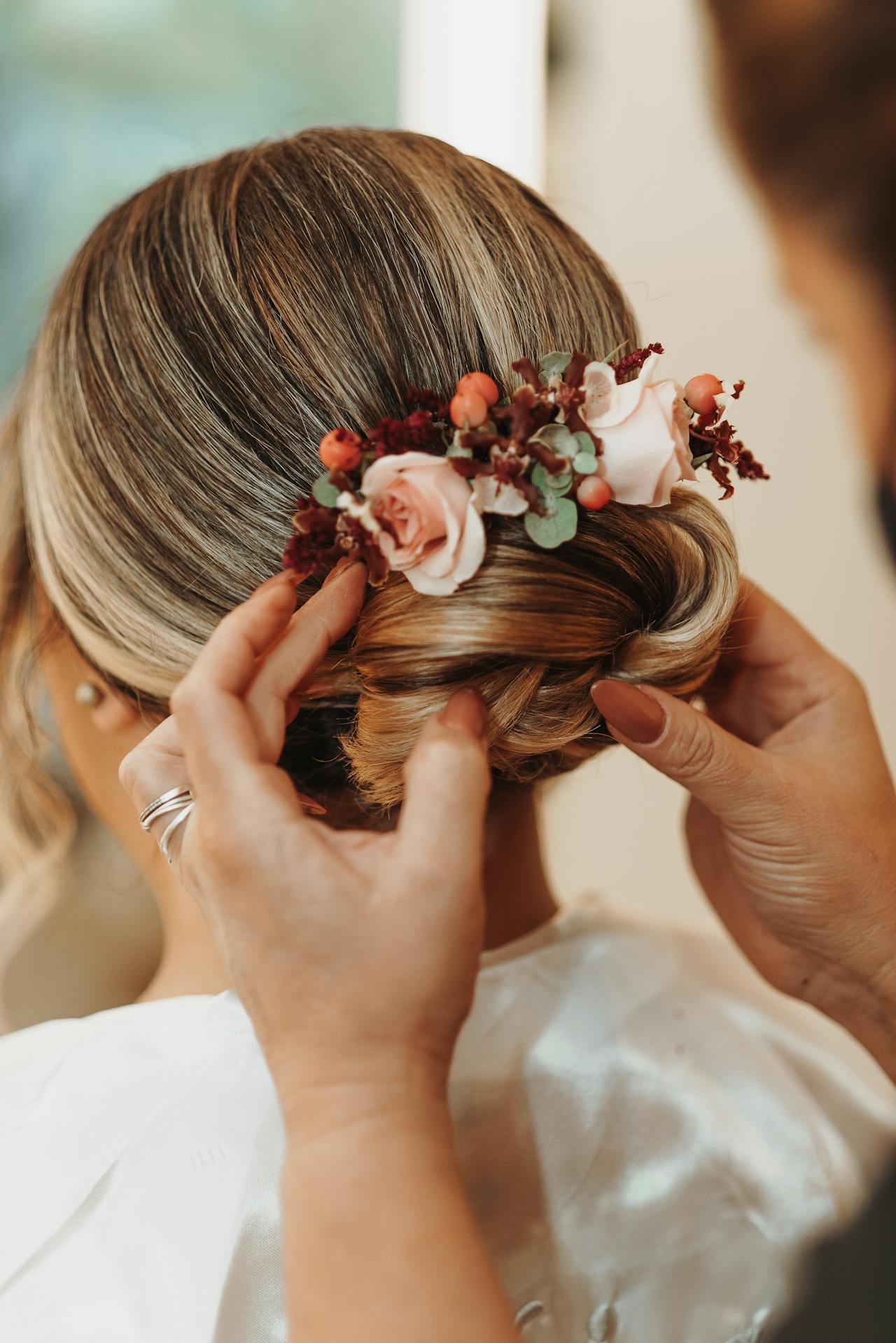 A woman fixing a bride's hair | Source: Pexels