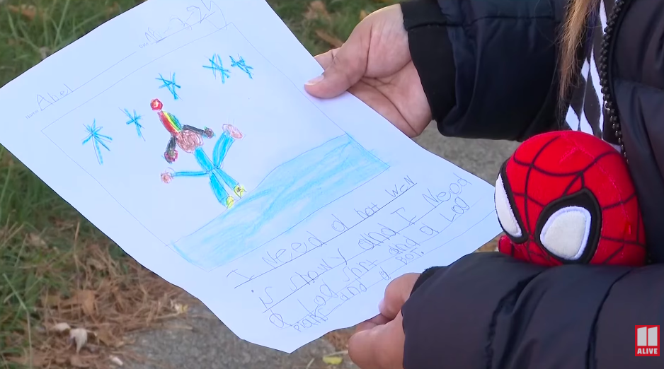 Karina Aquino holding her son's last picture and note he wrote. | Source: YouTube/11Alive