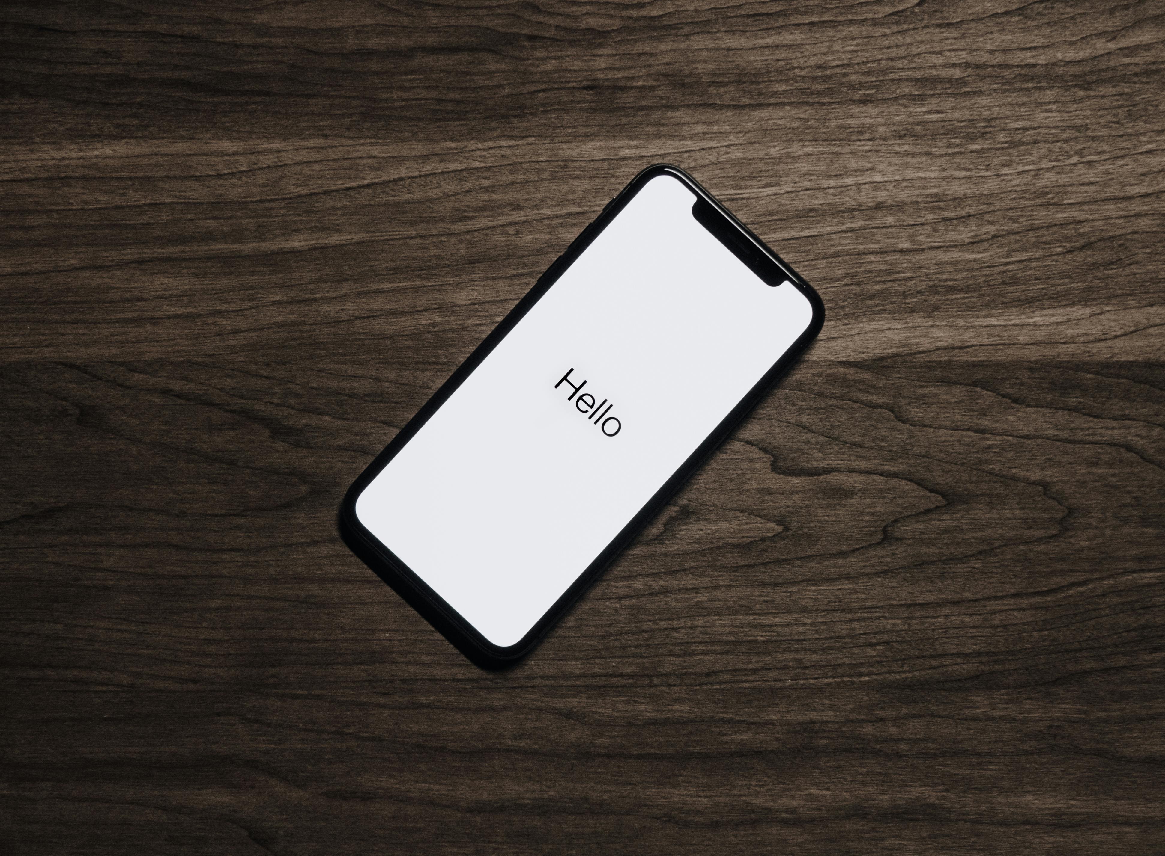 Black mobile phone on a brown table | Source: Pexels