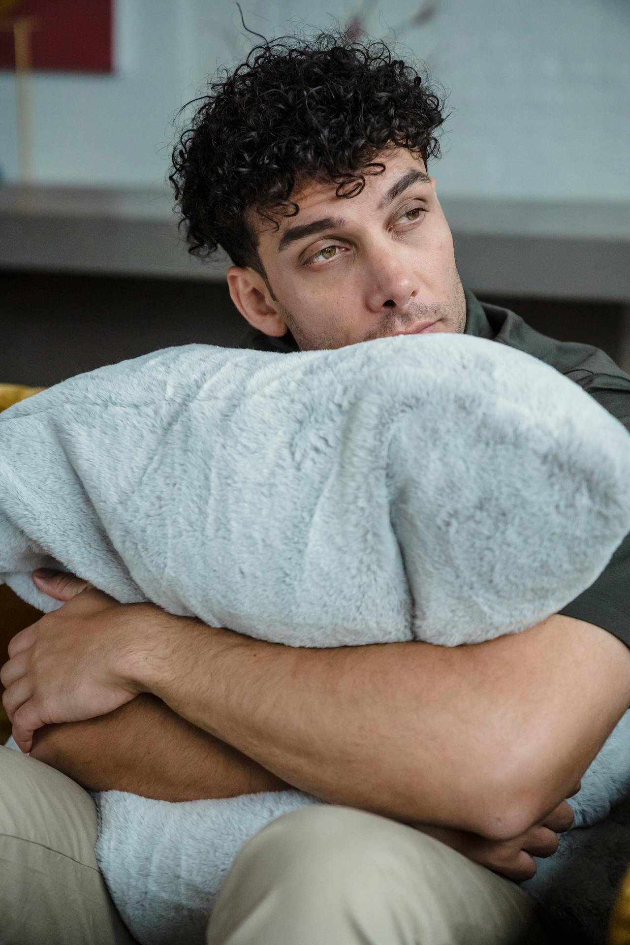 A man hugging his pillow and staring at someone | Source: Pexels