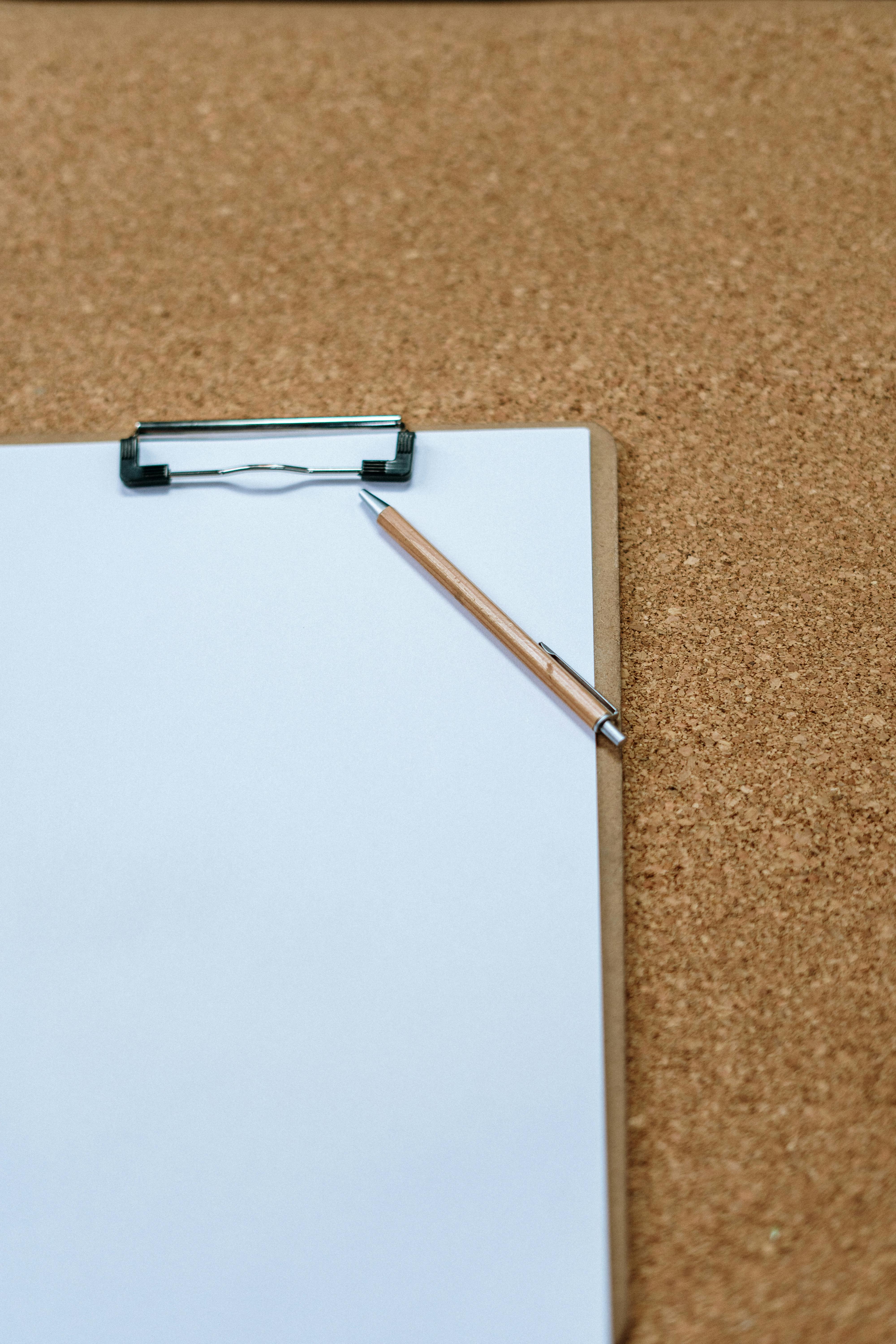 Paper and pen on a brown carpet | Source: Pexels