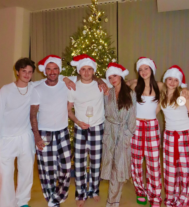 Victoria, David, Brooklyn, Cruz, and Harper Beckham, and Nicola Peltz in Christmas pajamas in a post dated December 25, 2023 | Source: Instagram/victoriabeckham