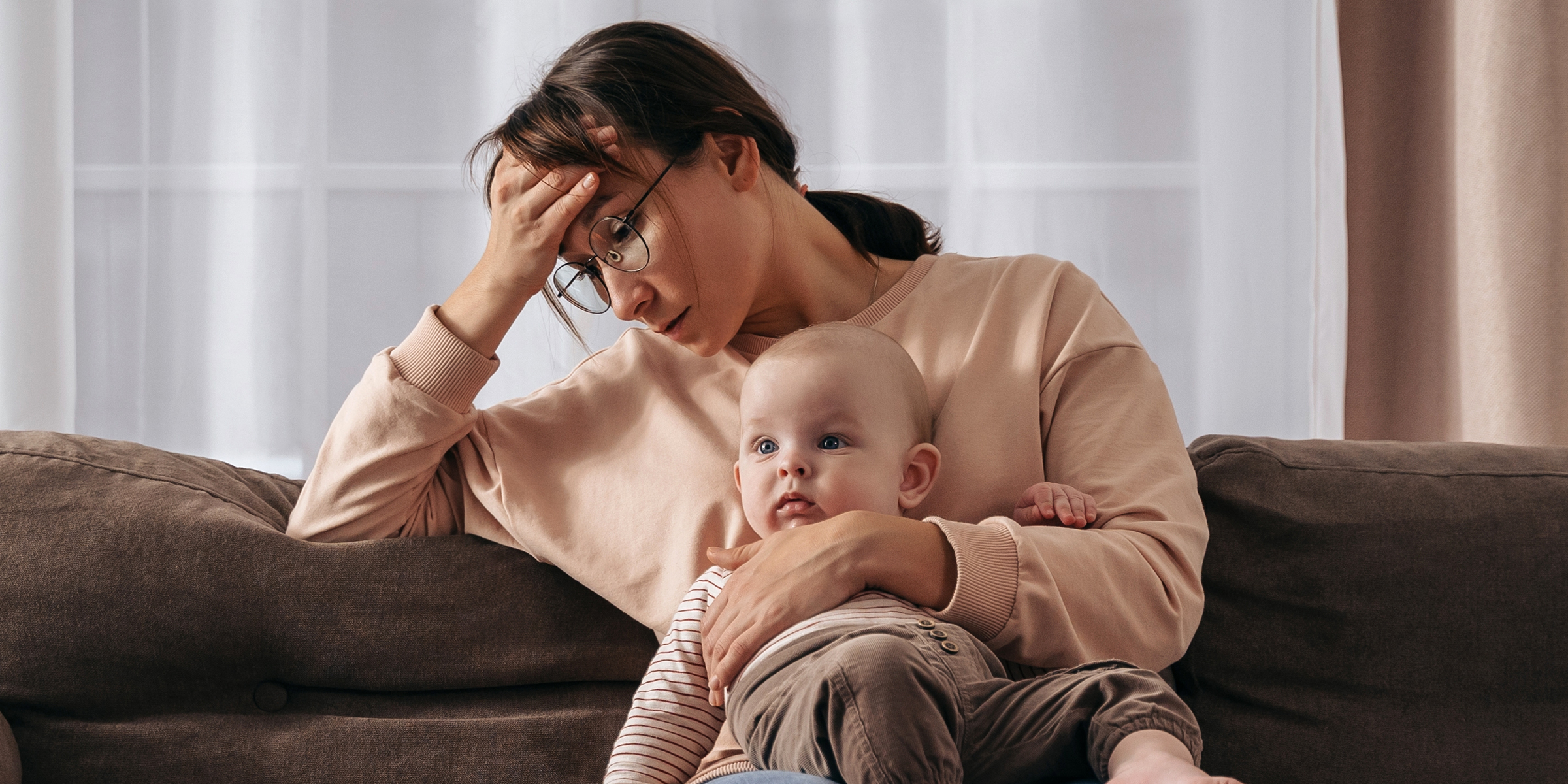 A stressed woman with a baby | Source: Shutterstock