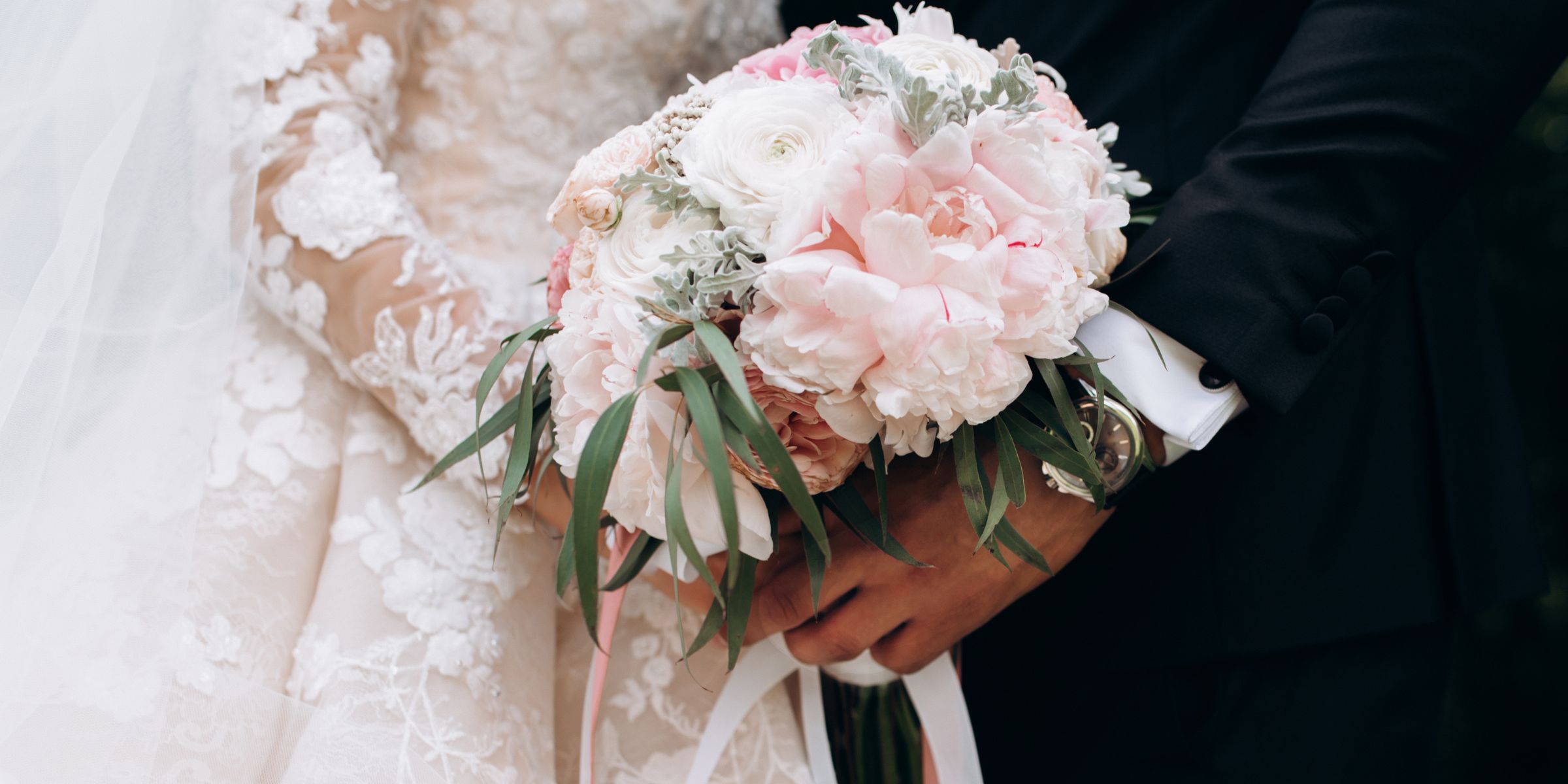 A bridal couple holding a bouquet | Source: No source