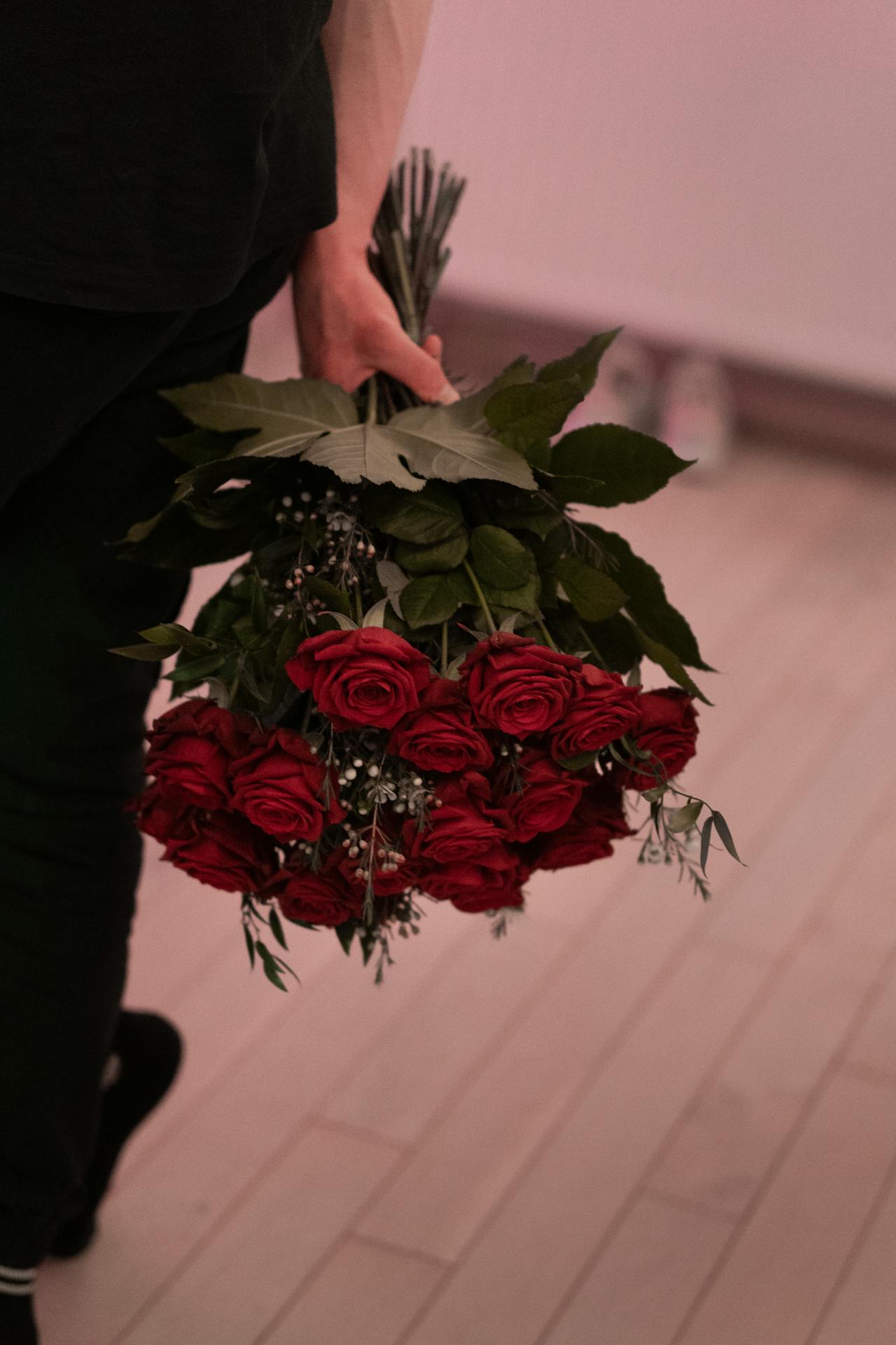 A man holding a bouquet of red roses | Source: Pexels