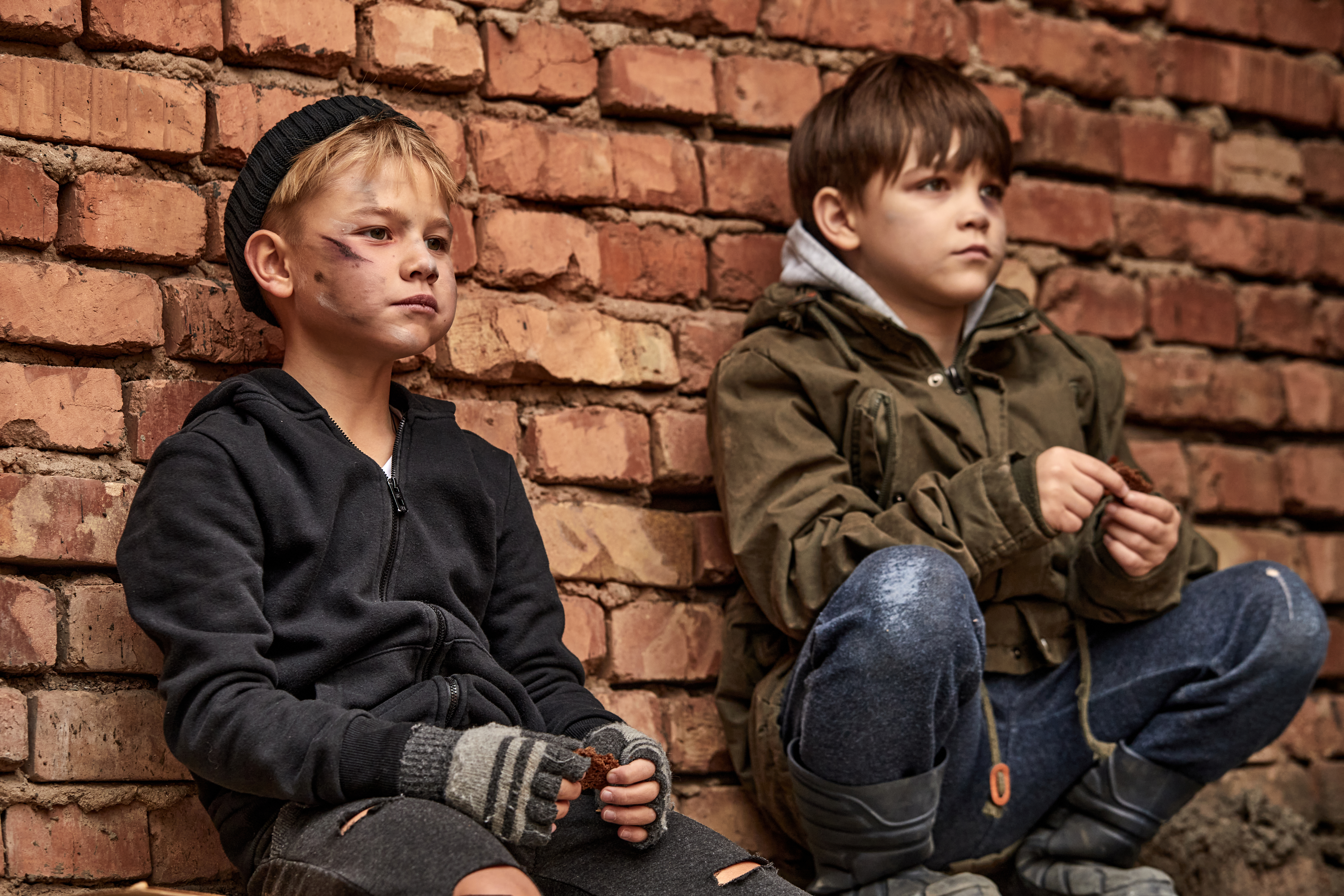 Two friendly street boys sharing piece of bread | Source: Shutterstock.com