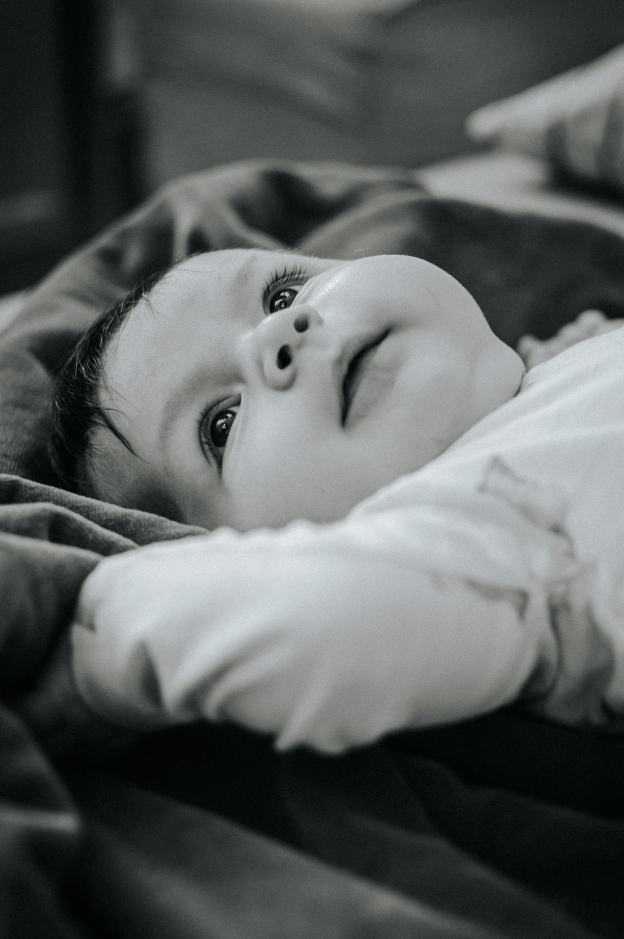 Grayscale shot of a toddler lying down | Source: Pexels