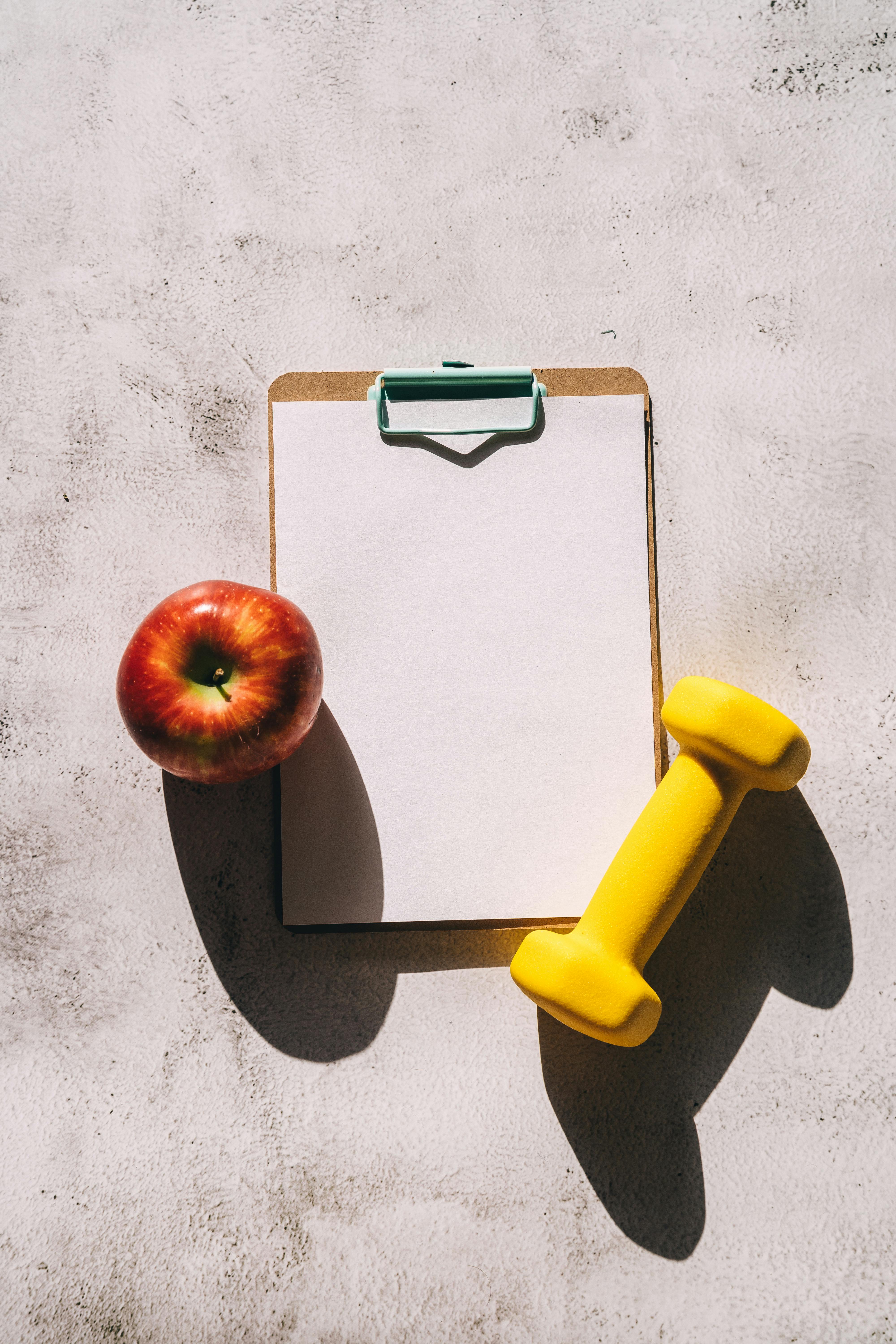 Apple and yellow dumbbell | Source: Pexels