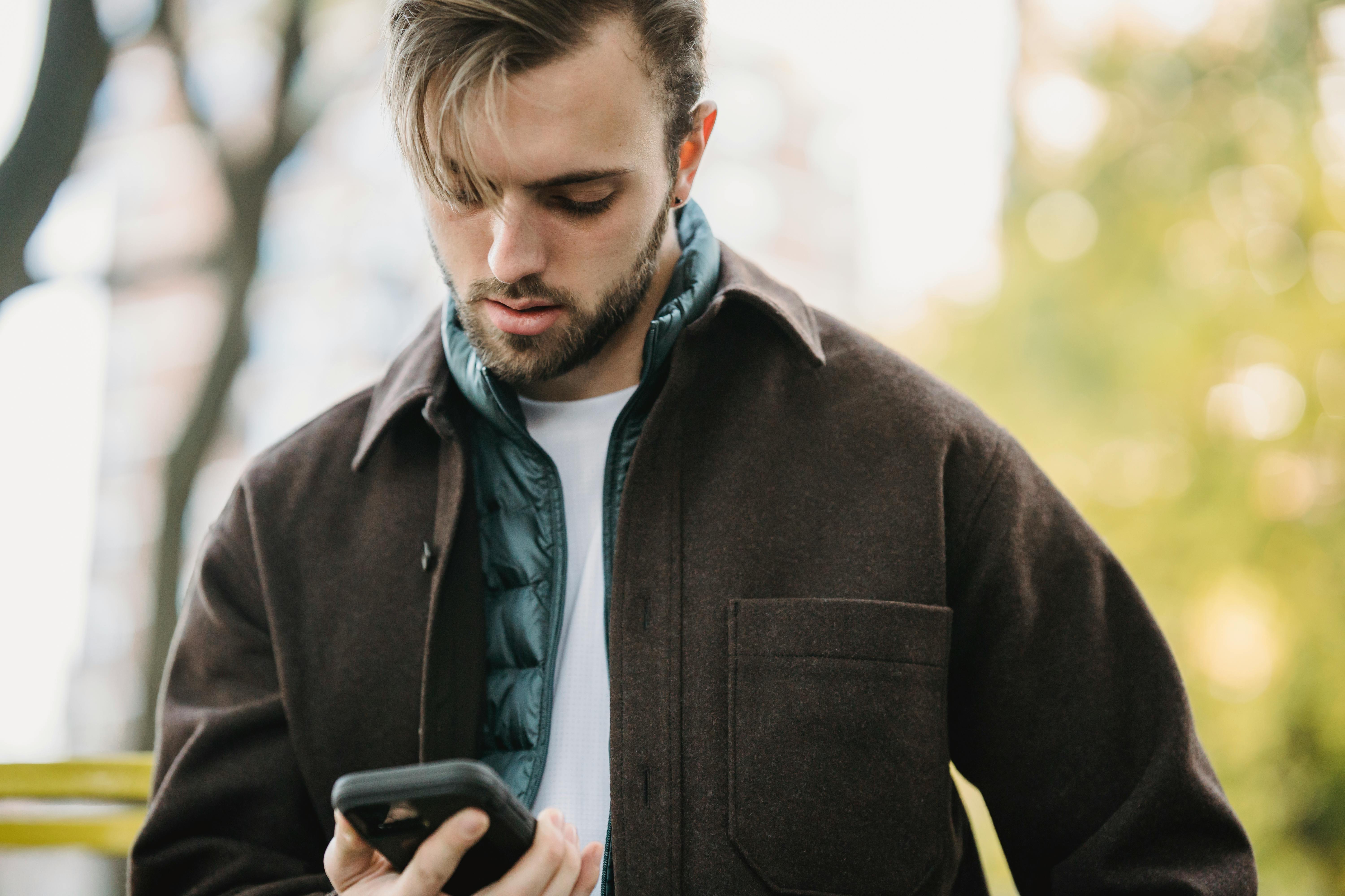 A serious man looking at his phone | Source: Pexels