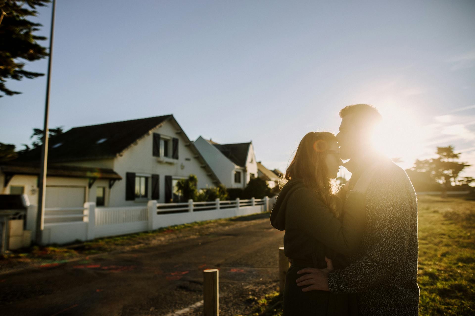 A man kissing a woman on the forehead in front of a house | Source: Pexels