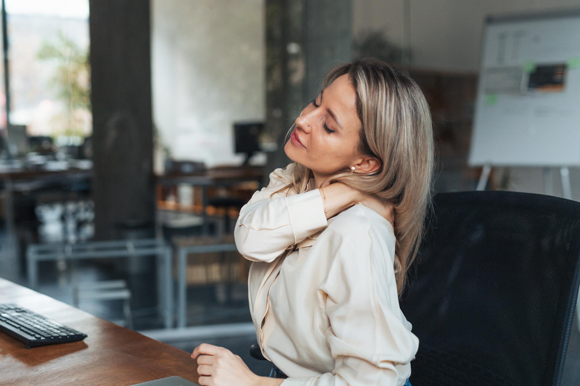 A woman suffering from a stiff neck at work | Source: Getty Images