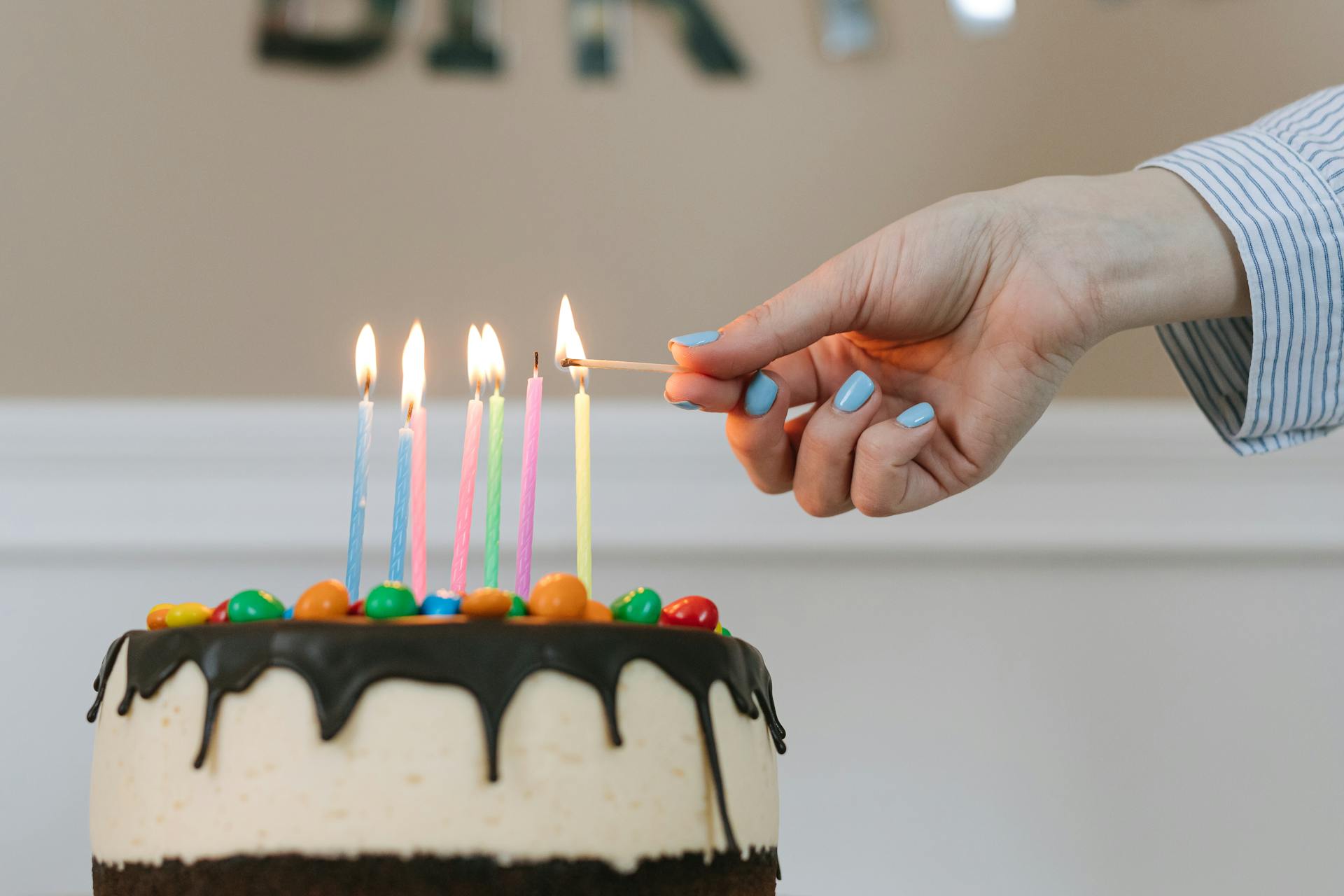 A woman lighting candles on a cake | Source: Pexels
