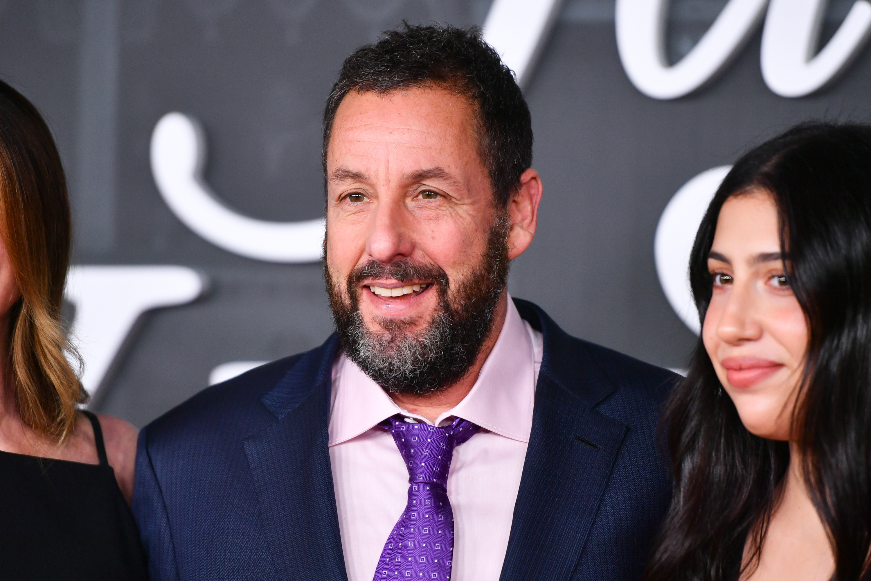 As the family poses for photos, this picture focuses on Adam and Sadie Sandler at the "Jay Kelly" premiere. Father and daughter smile warmly, with a glow in Sadie’s eyes as she stands beside her co-star and dad.
