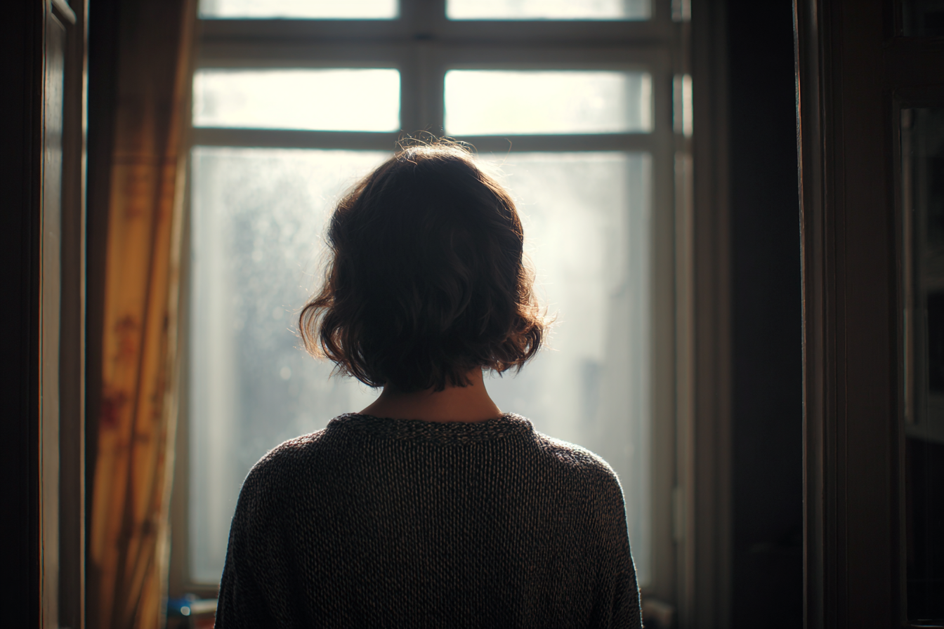 A woman standing near a window | Source: no source