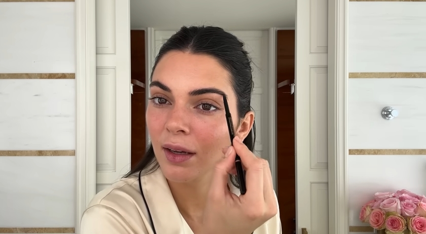 Kendall Jenner doing her Spring French girl makeup routine from a post dated April 11, 2024. | Source: YouTube\Vogue