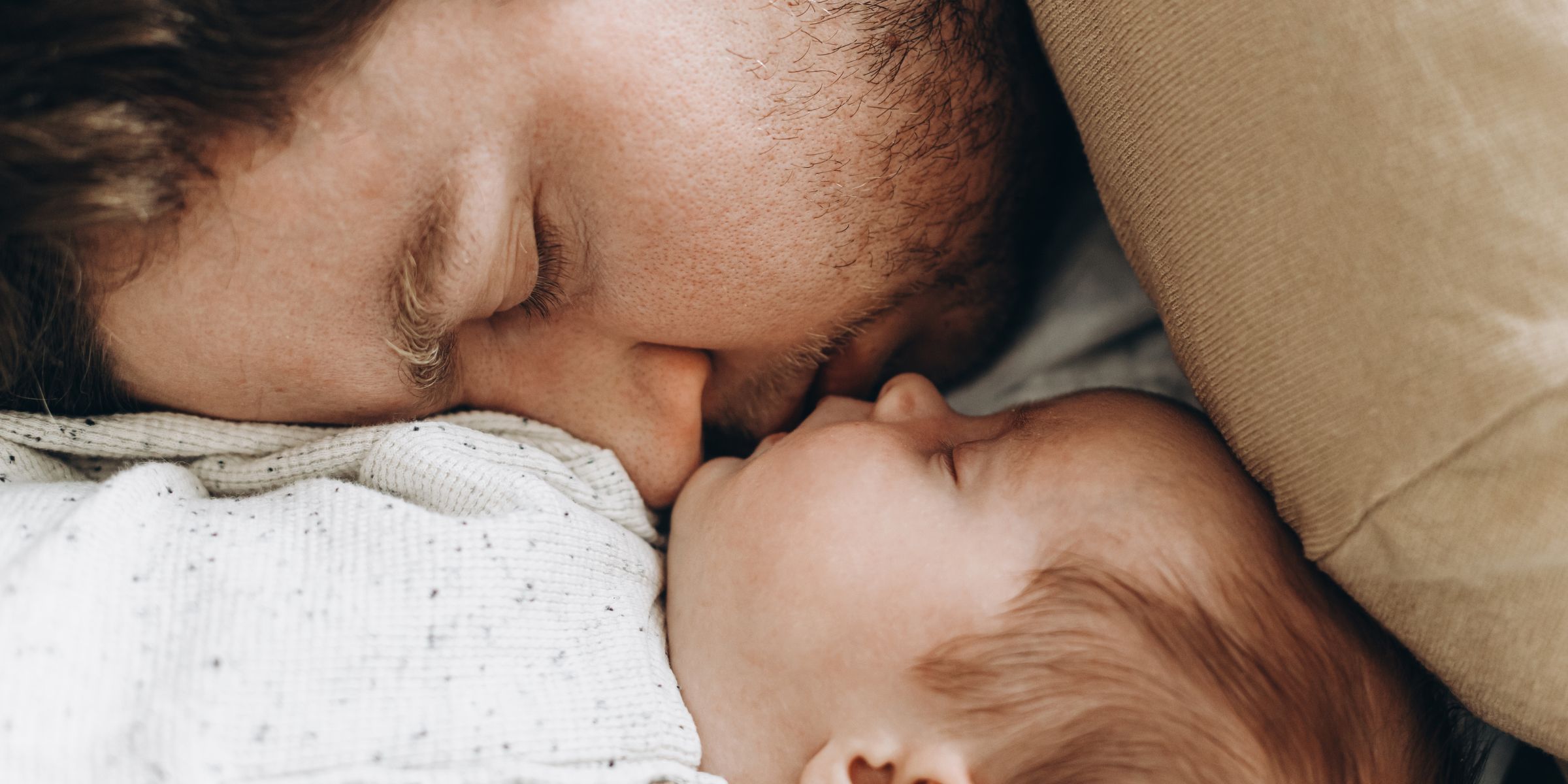A man sleeping next to a newborn baby | Source: Shutterstock