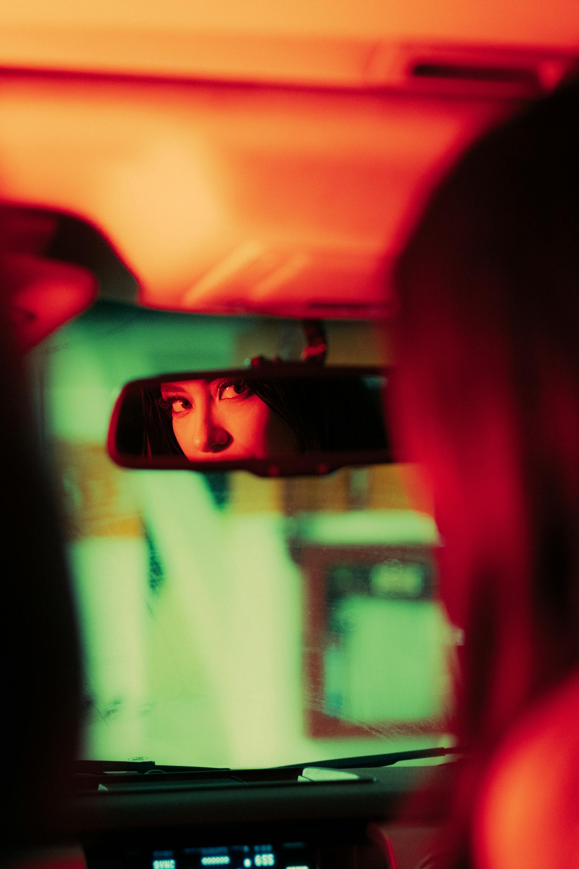 A woman checking her rearview mirror while driving | Source: Pexels
