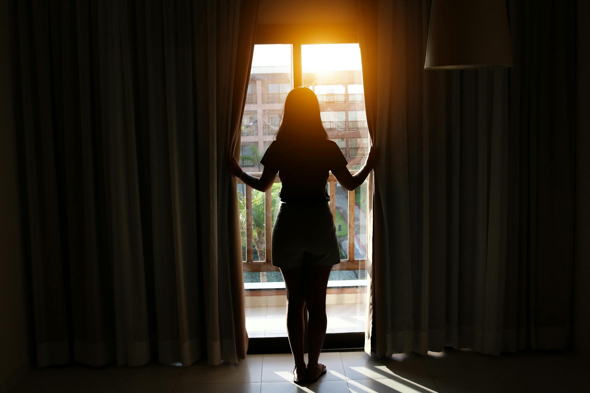 A young woman standing beside the window | Source: Pexels