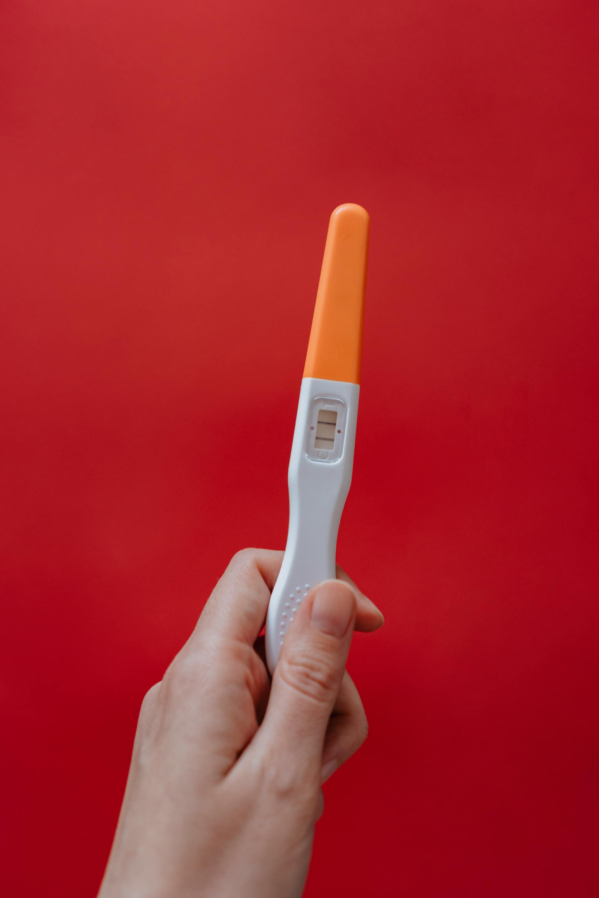 A woman holding a pregnancy test | Source: no source