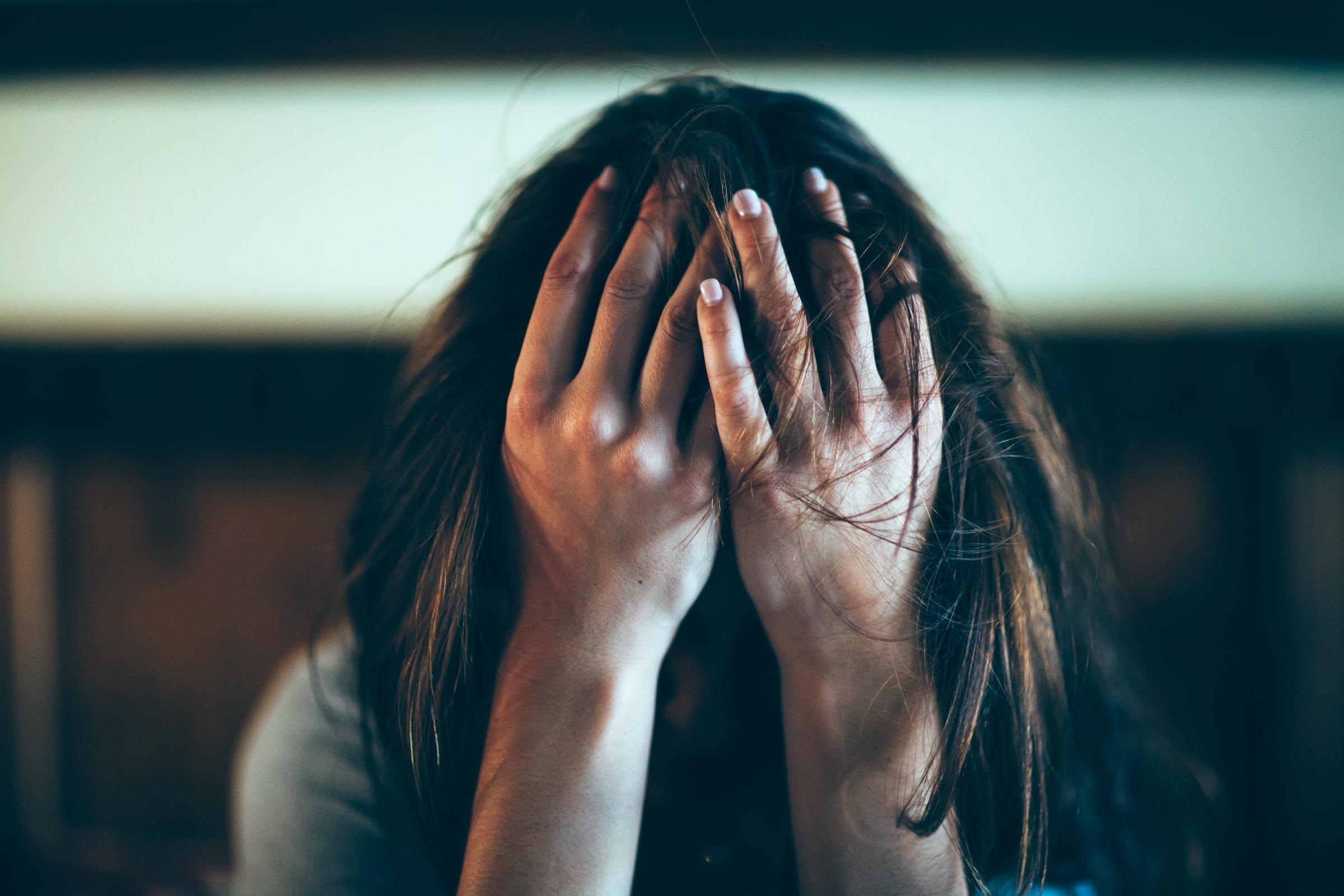 A woman covering her face in frustration | Source: Getty Images