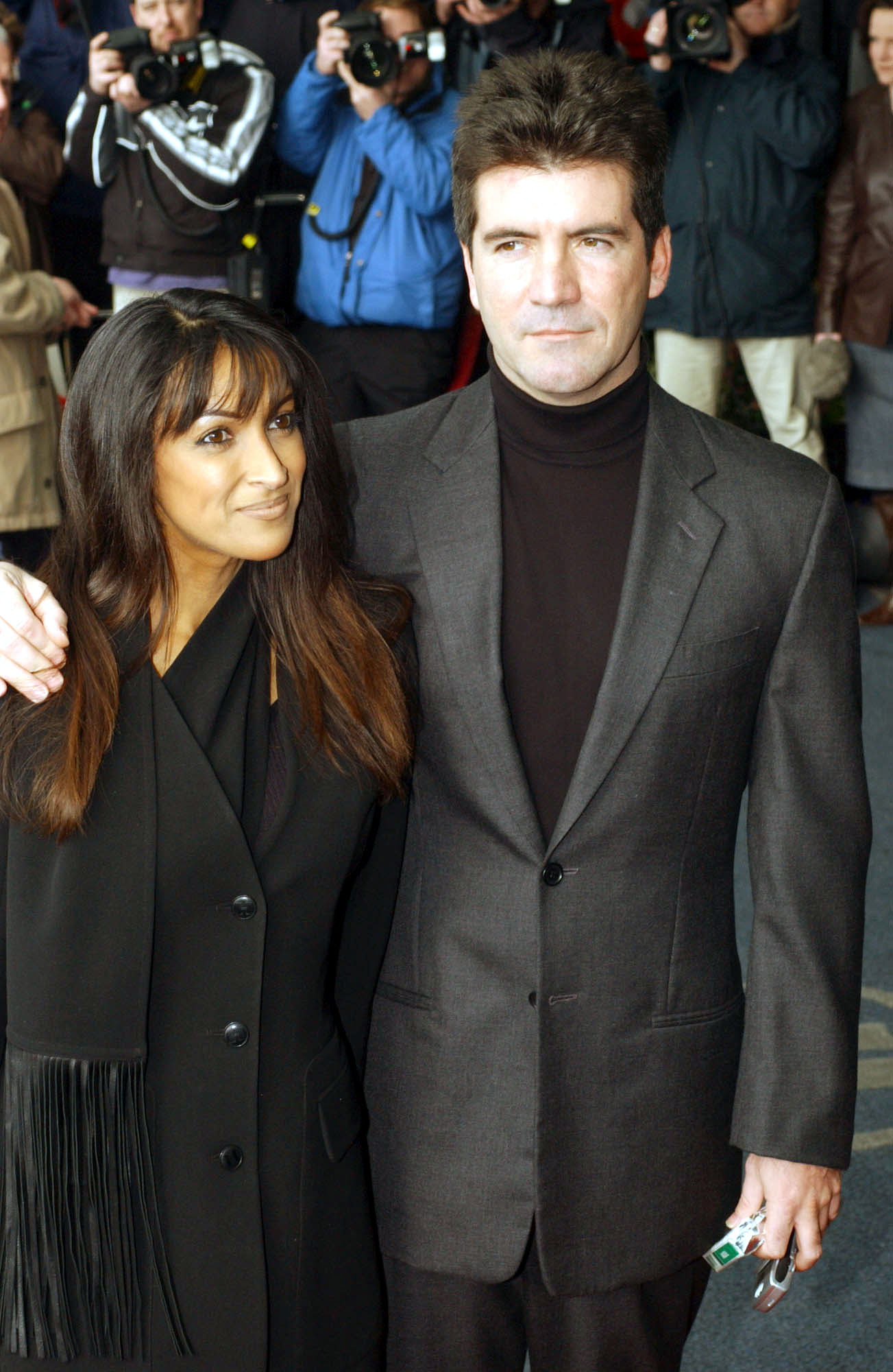 Simon Cowell cuts a slick figure in 2002, arriving at The Mirror Pride of Britain Awards in London. Clad in a sharp dark suit, the rising TV titan is swarmed by flashing cameras as he basks in the glow of his early fame.