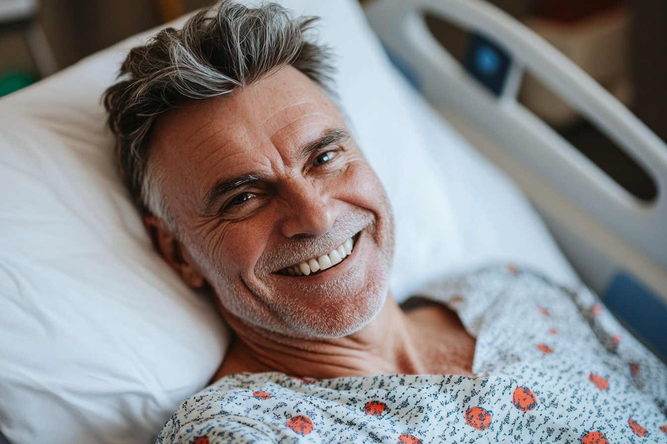 A man in a hospital bed smiling at someone | Source: No source